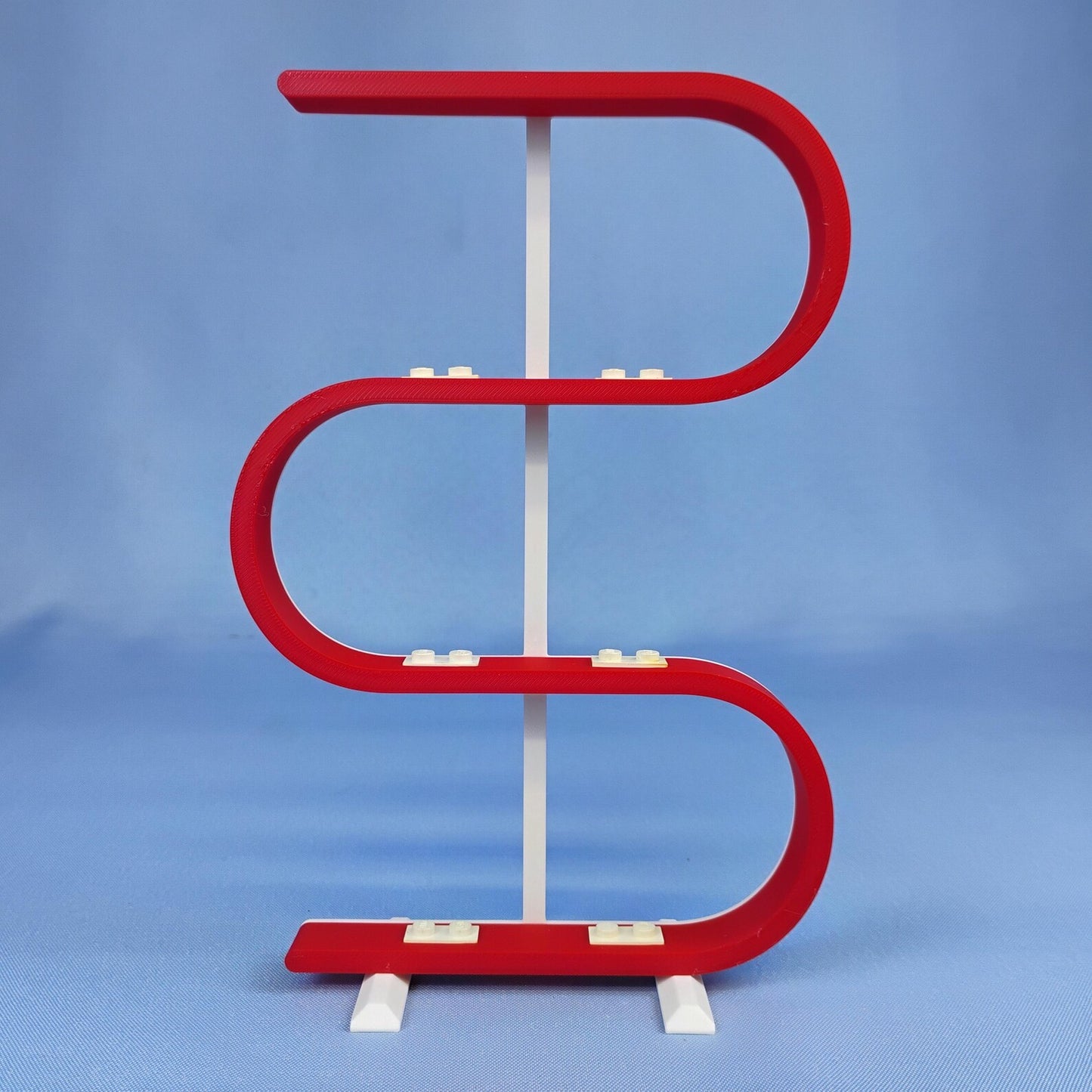 Empty red squiggle display stand for LEGO® minifigures on a blue background