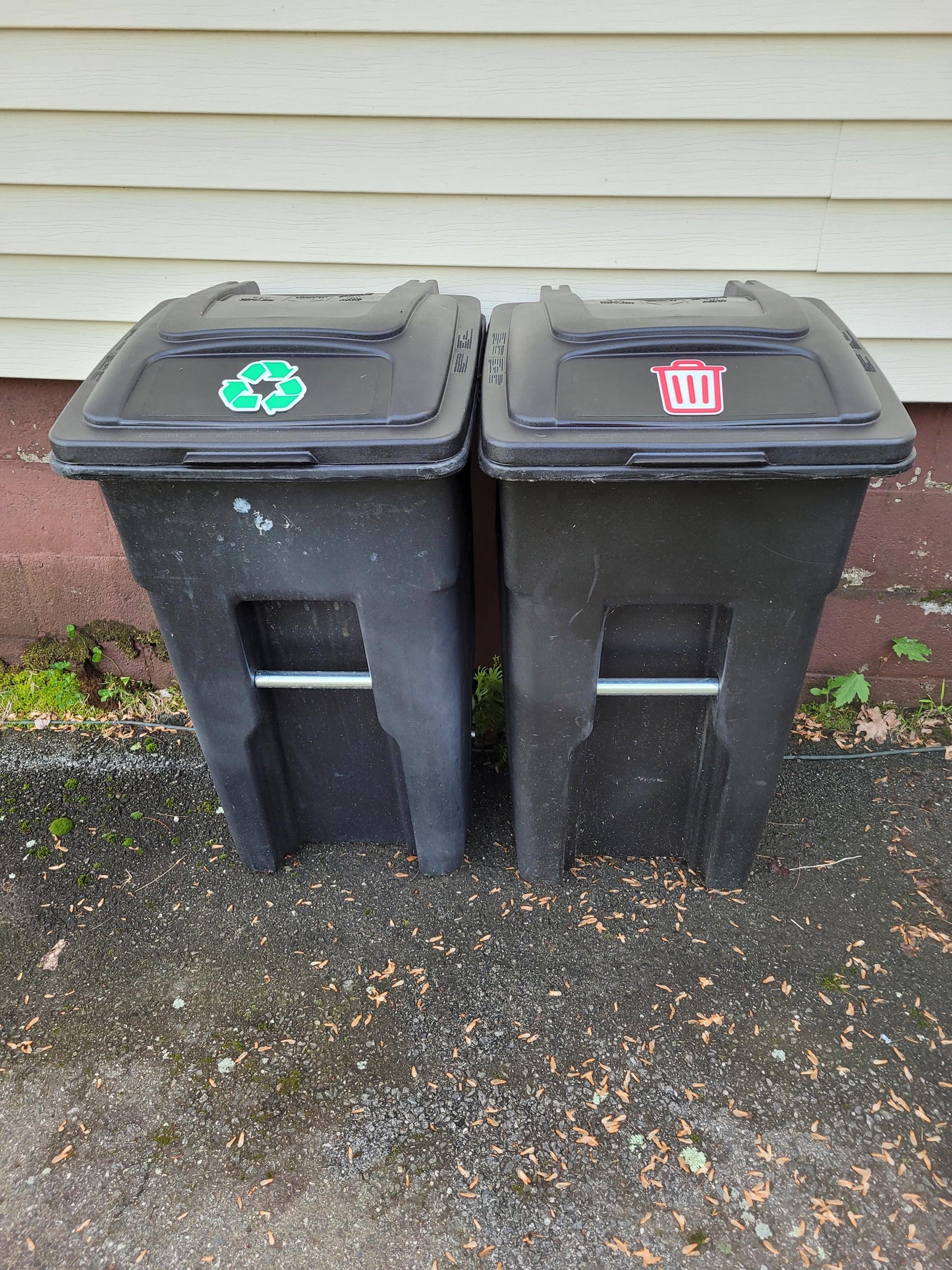 Trash and recycling signs mounted on outdoor curbside bins to clearly mark garbage and recycling containers