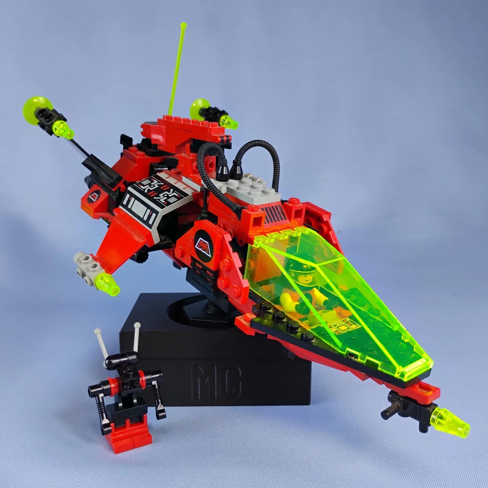 Red LEGO® ship on black adjustable desk display stand with custom text base.