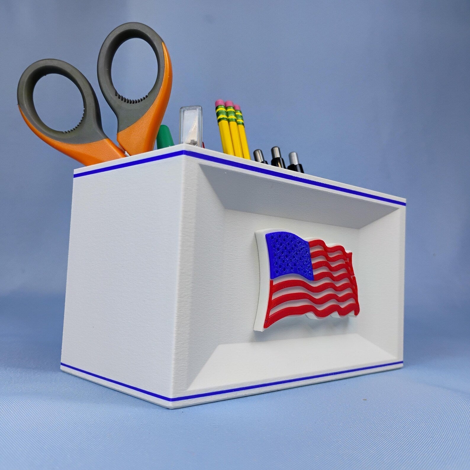 White American flag desk organizer with blue accents holding pens, pencils, and scissors
