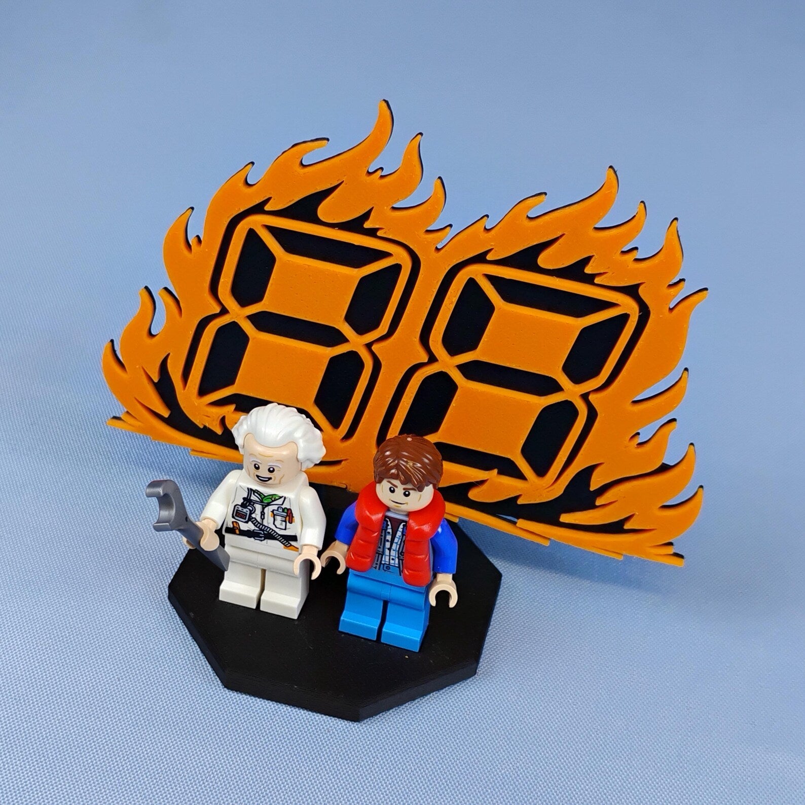 88 MPH flame backdrop display for LEGO® Back to the Future minifigures with black base and two figures shown front and center.