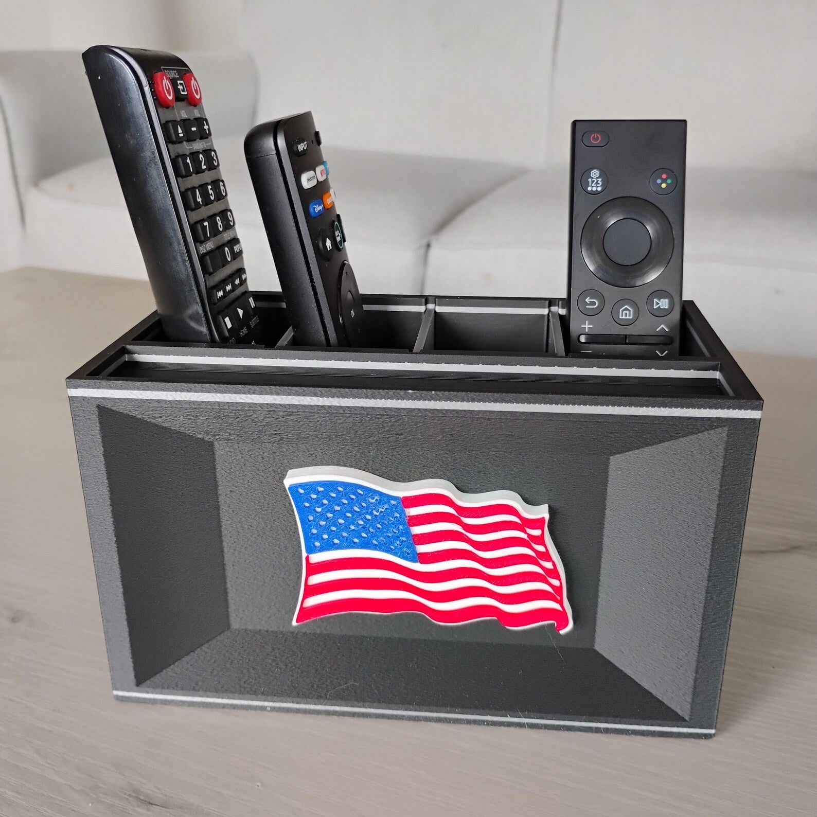 Black American flag desk organizer holding remotes on a tabletop