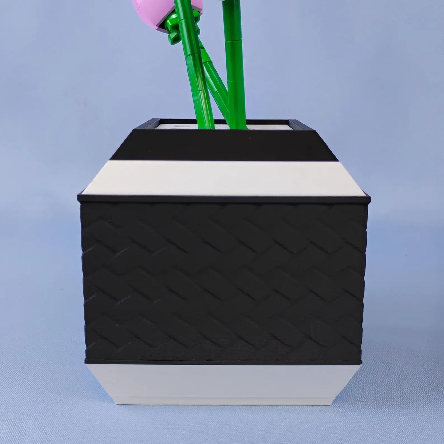 Black geometric vase holding LEGO® botanical stems in a removable top insert