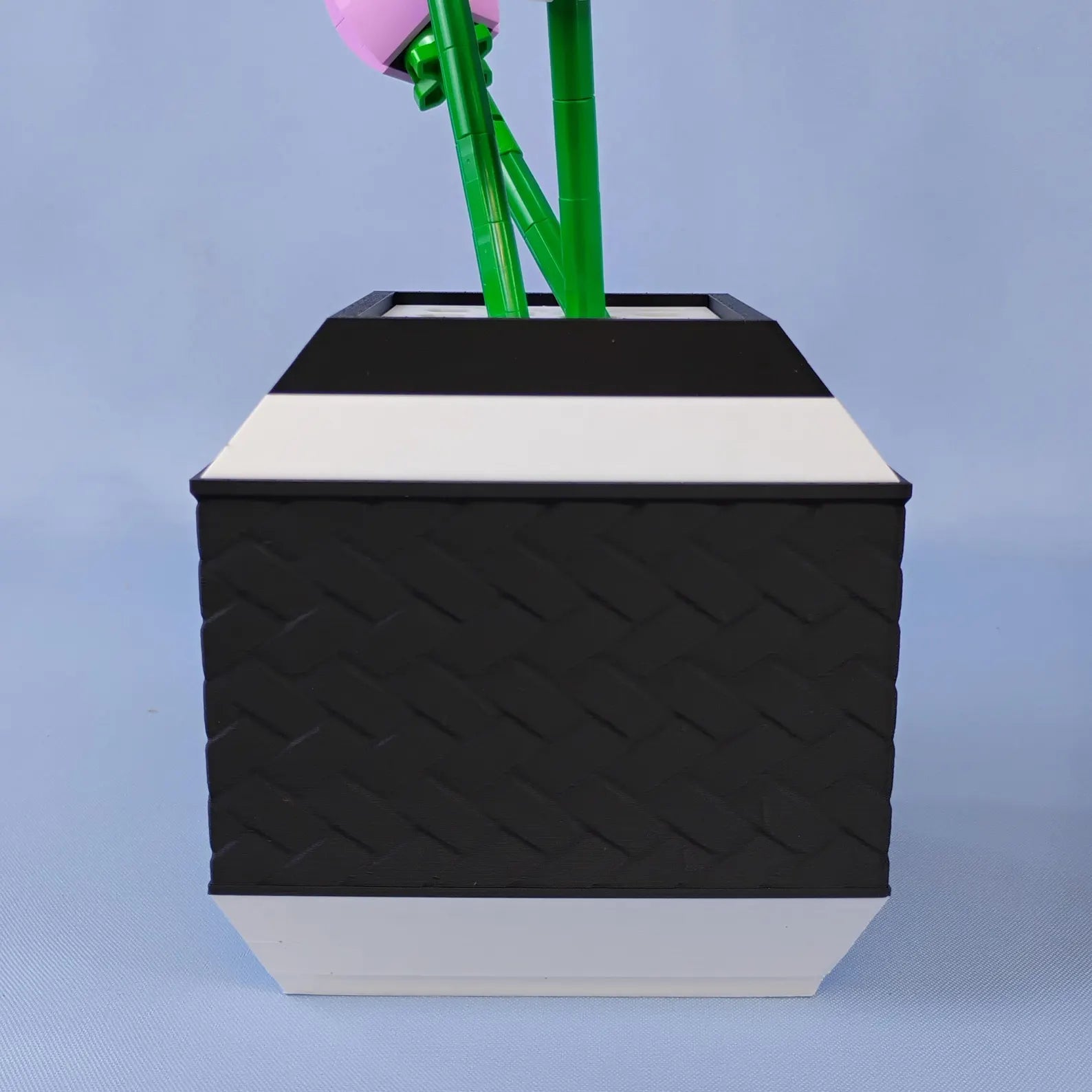 Black geometric vase holding LEGO® botanical stems in a removable top insert
