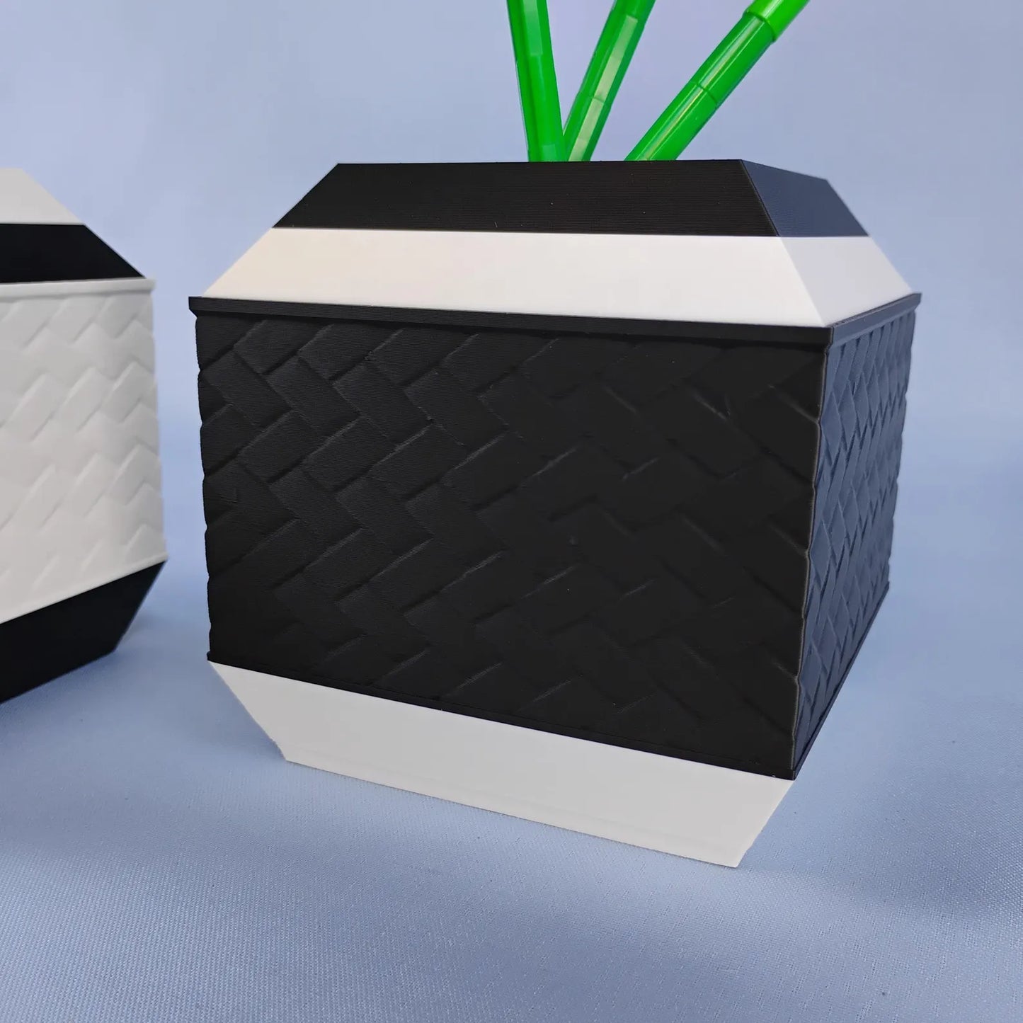 Black geometric vase with textured side detail and white accent trim