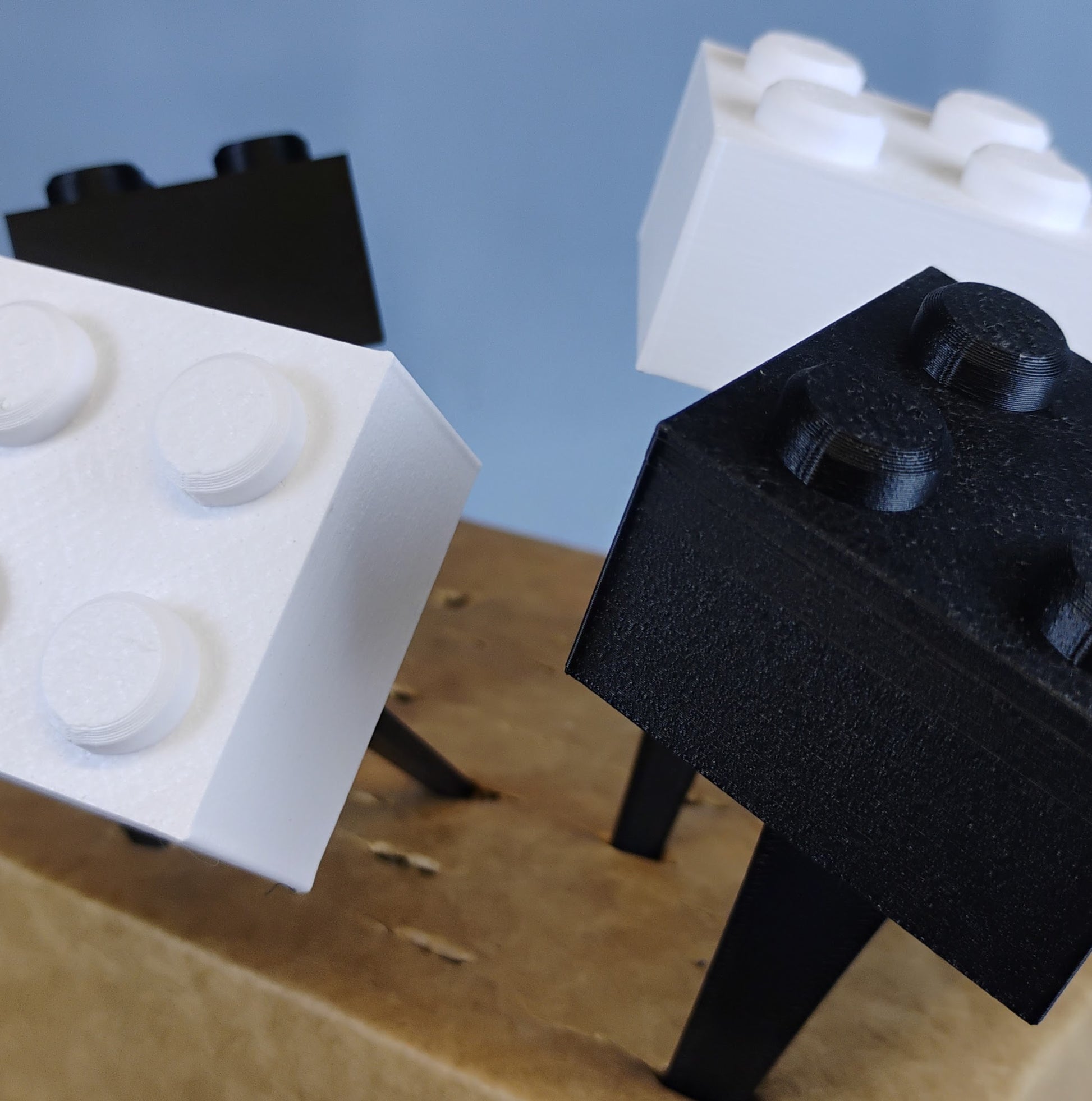 Black and white building brick plant stakes shown close up with removable brick-shaped toppers.