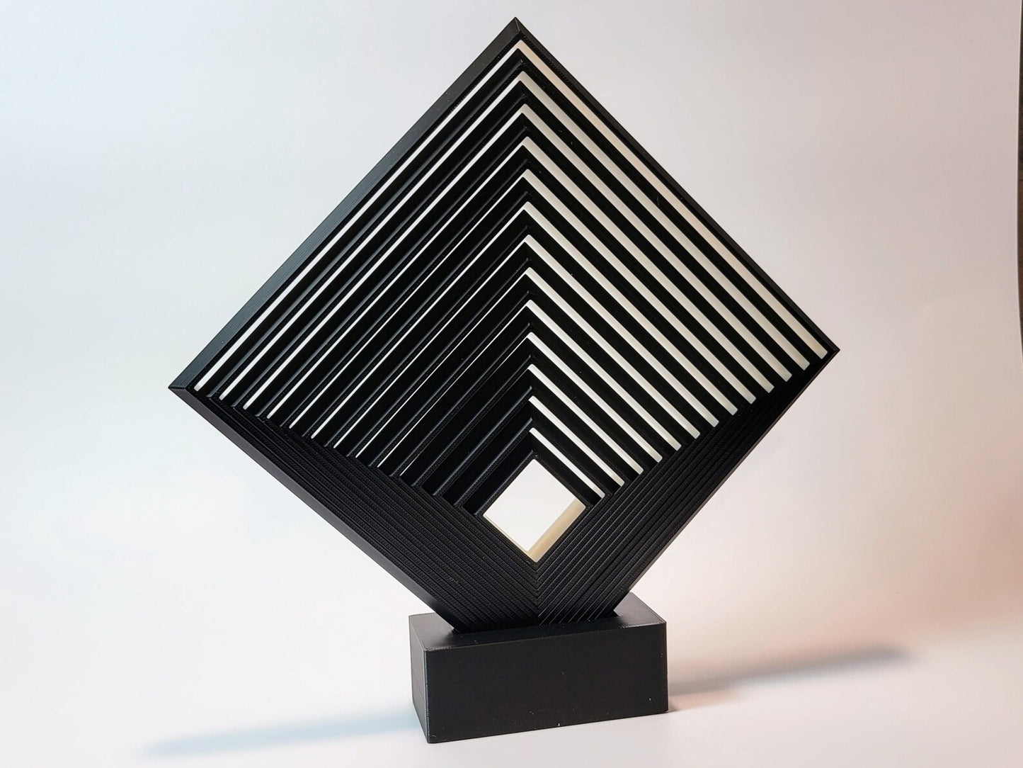 Black and white geometric fidget square displayed upright as interactive desk art