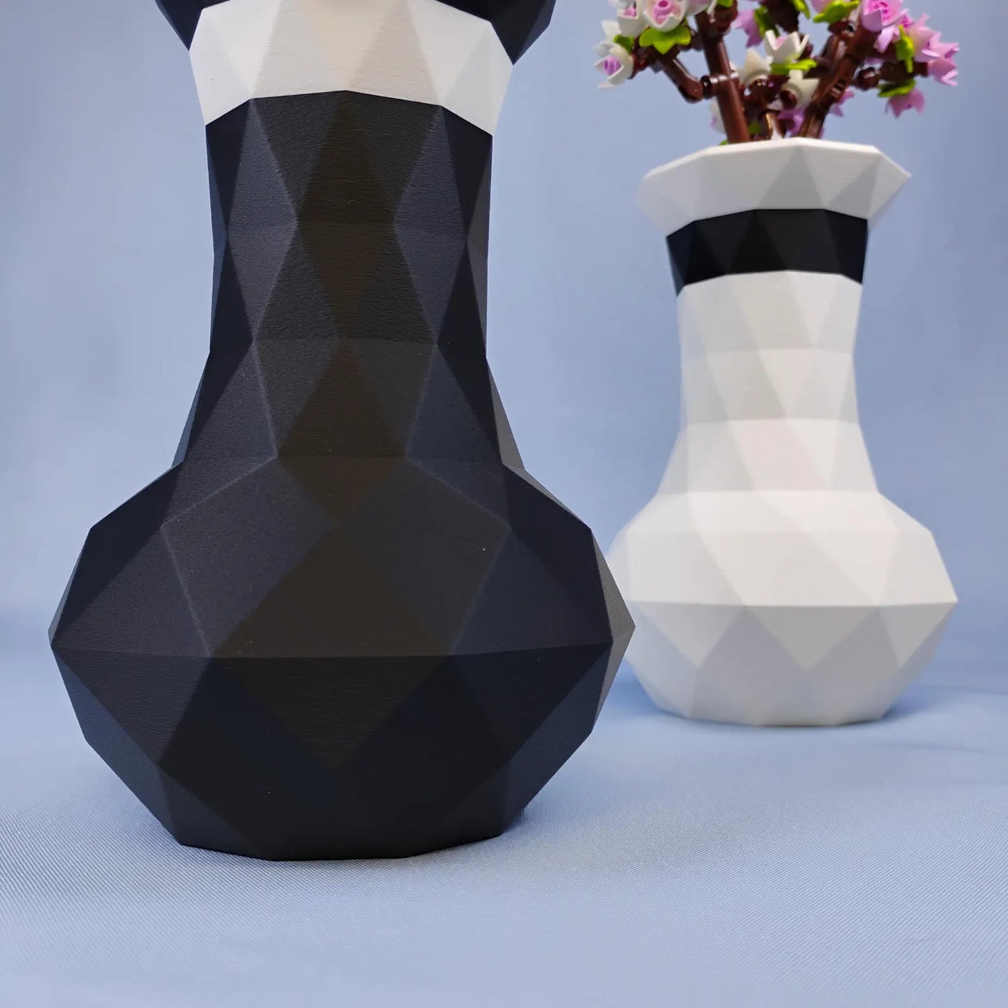 Black and white geometric vases shown together with faceted sides and accent stripe detail