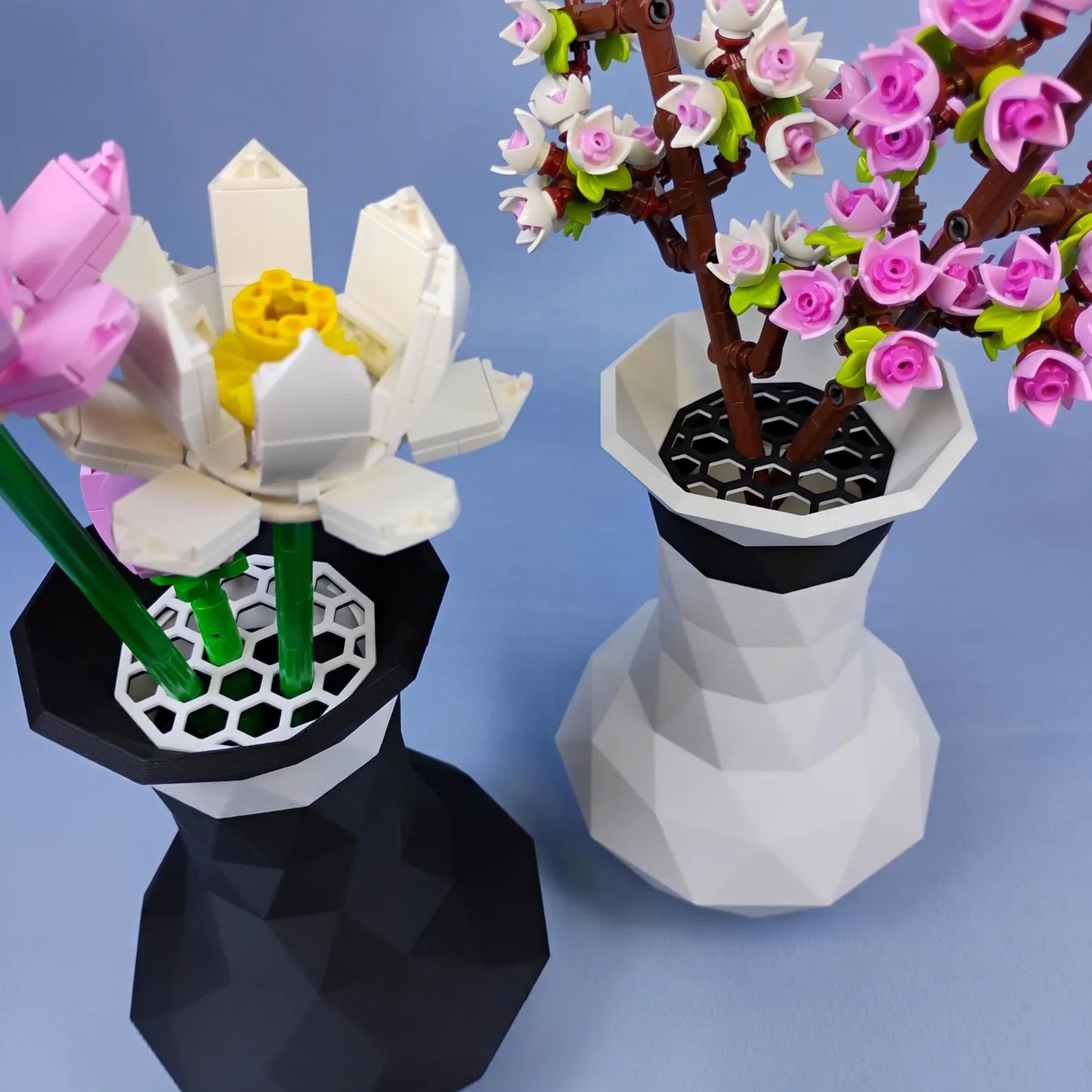 Black and white geometric vases displaying LEGO® botanical flowers with top grid inserts