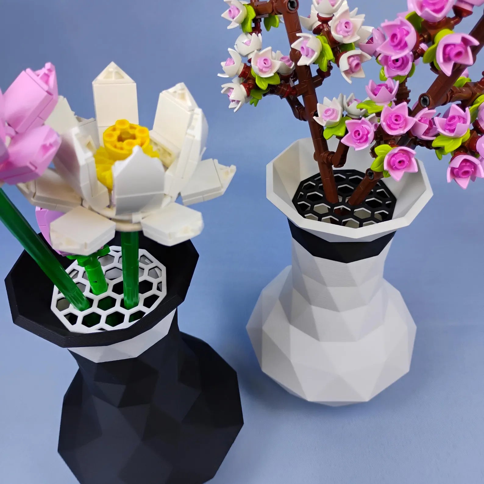 Black and white geometric vases displaying LEGO® botanical flowers with top grid inserts