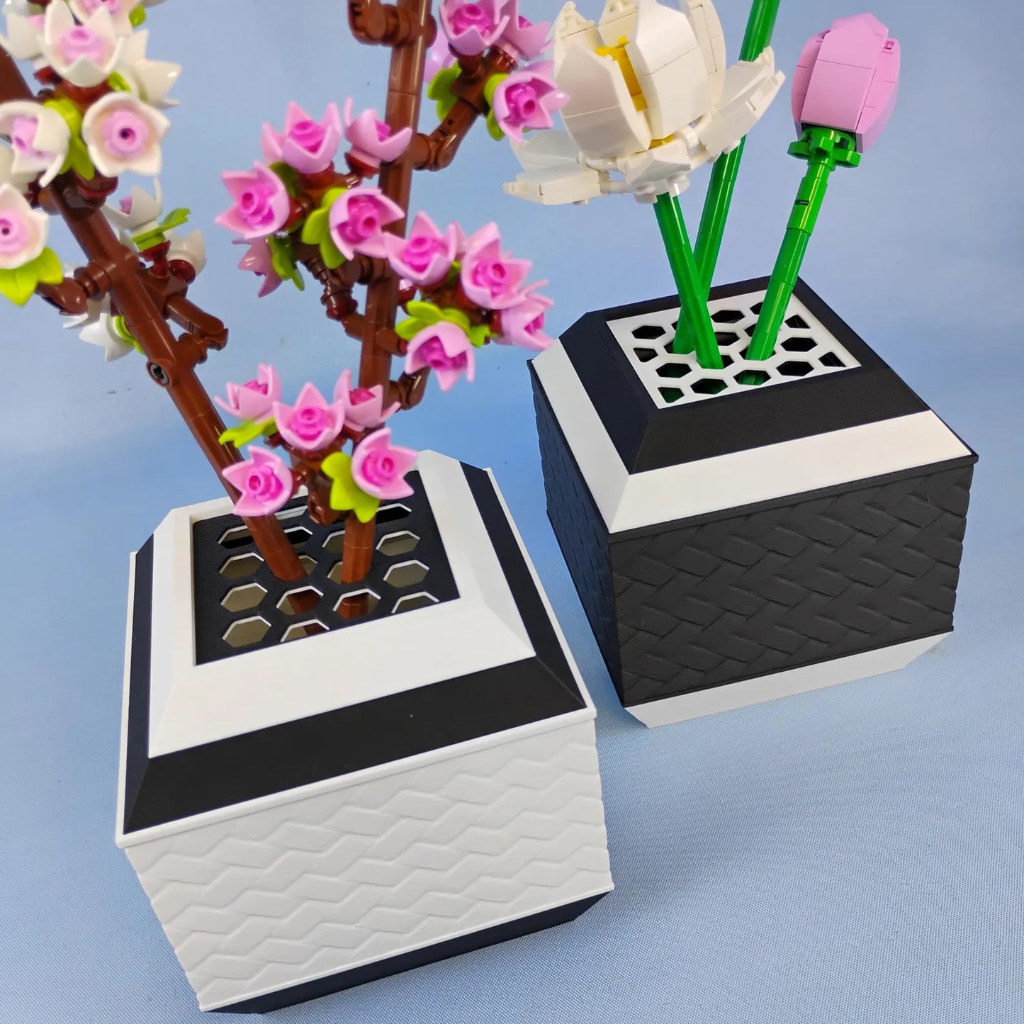 Black and white geometric vases displaying LEGO® botanical flowers with stem grid inserts