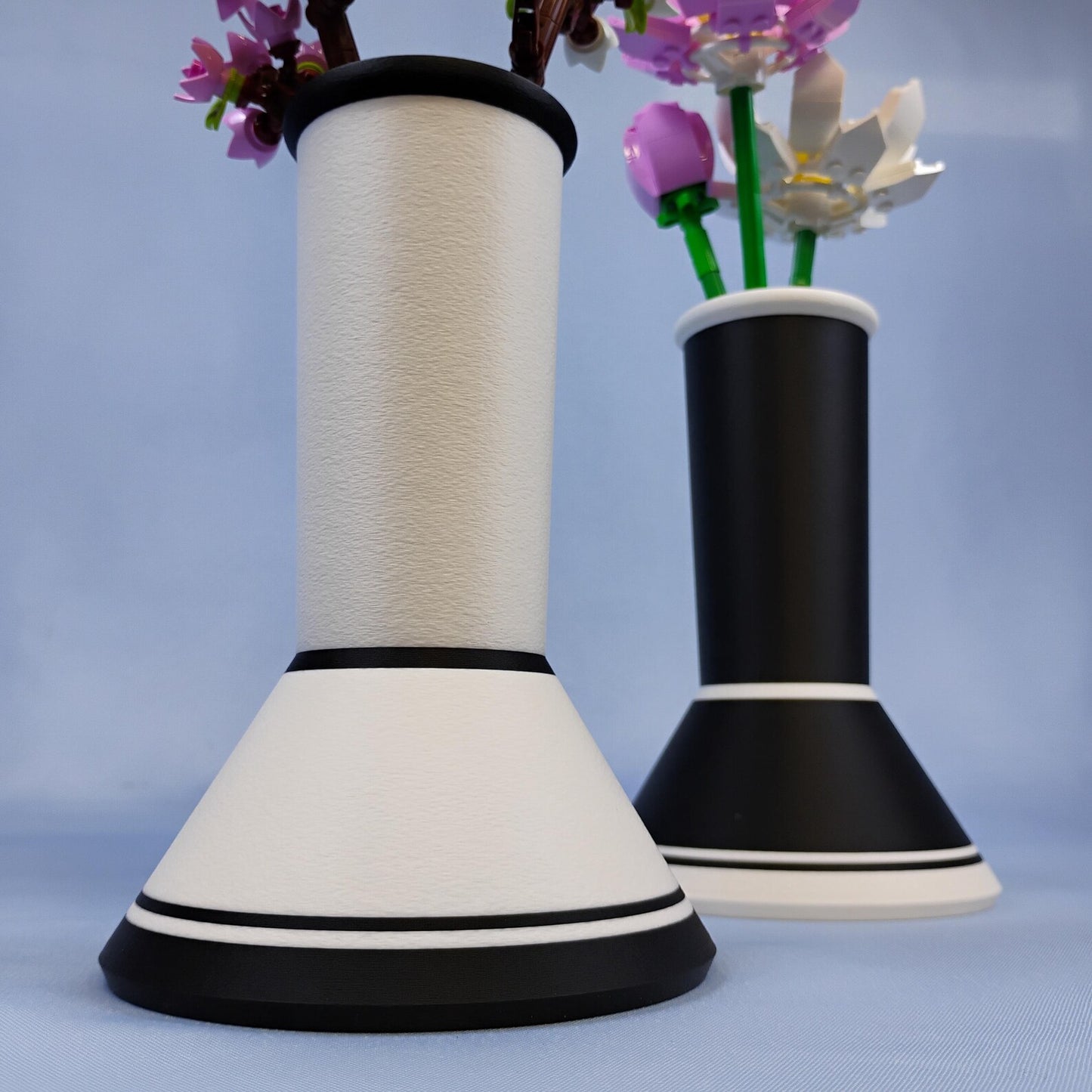 Black and white minimalist vases shown together with clean modern shape and accent trim