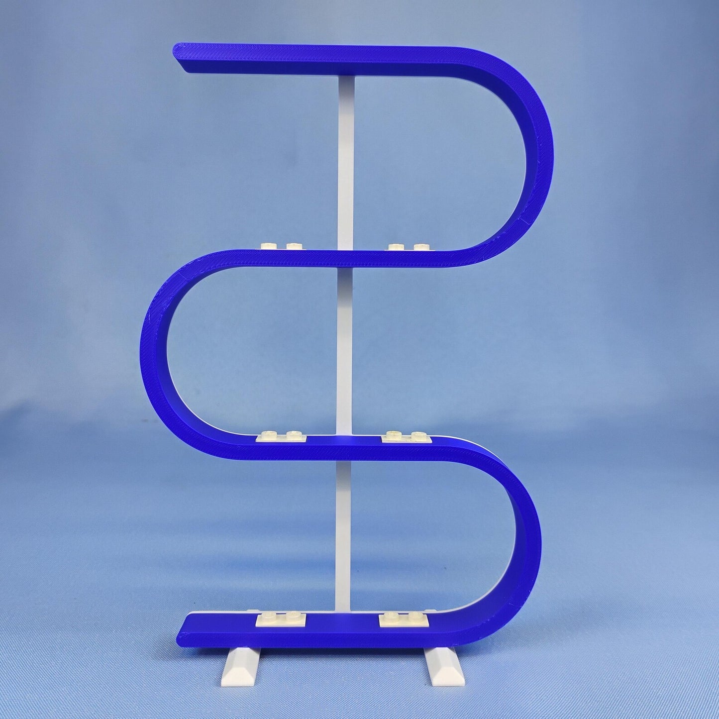 Empty blue squiggle display stand for LEGO® minifigures on a blue background