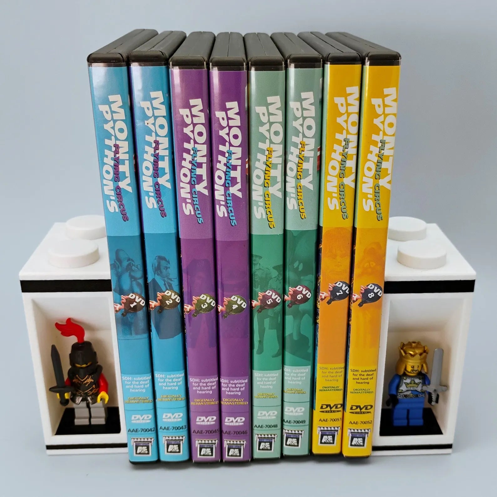 White bookends holding DVD cases with recessed LEGO® minifigure display alcoves on each side