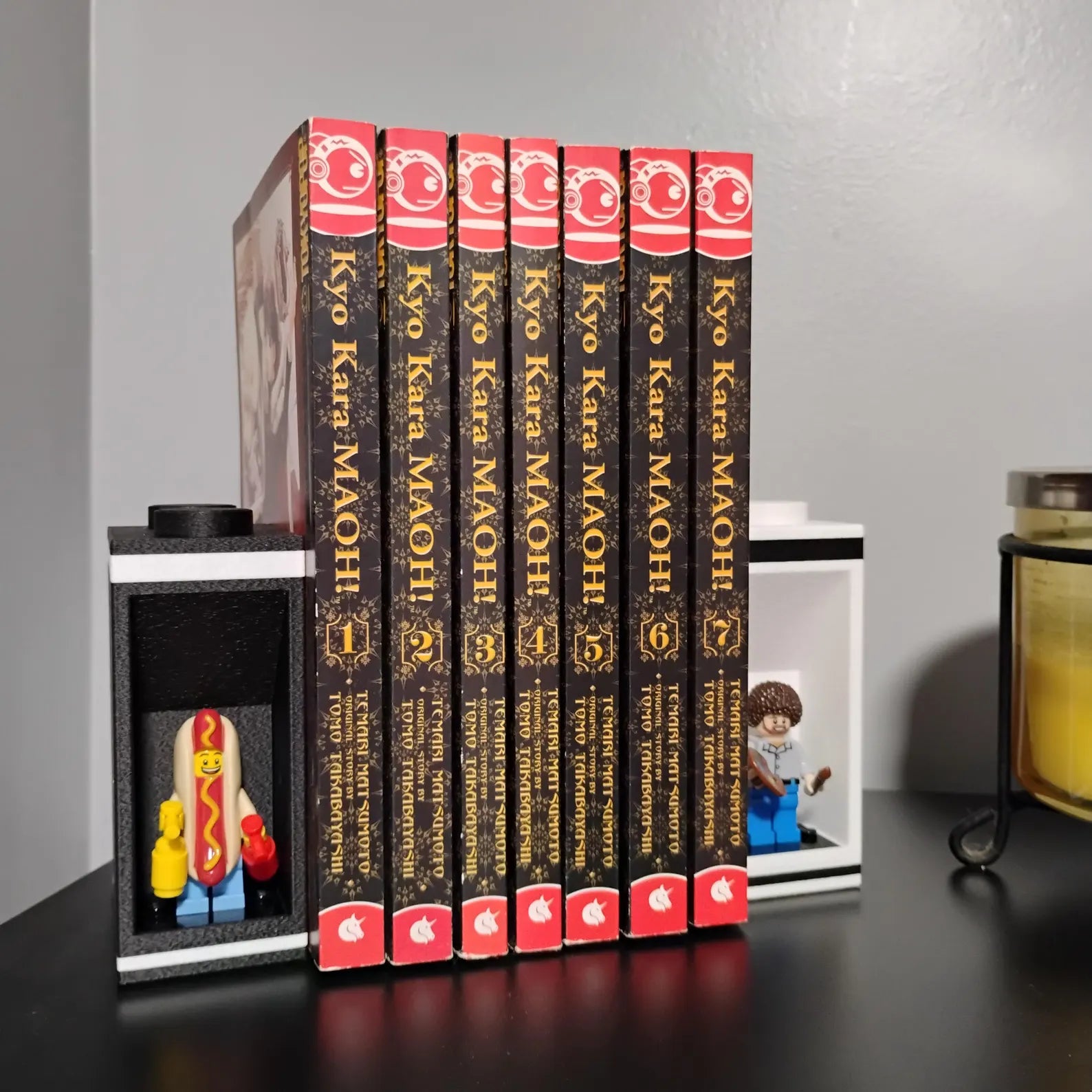 White bookends holding manga volumes with LEGO® minifigures displayed in recessed side alcoves