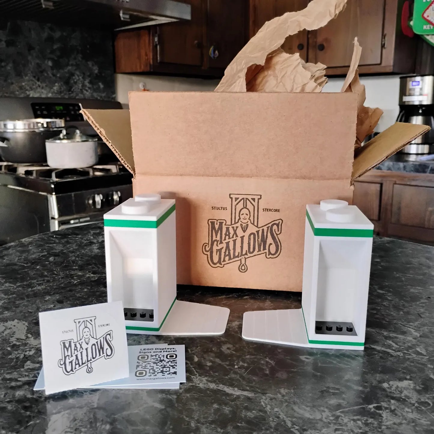 Bookends shown with packaging and included LEGO® display mounts on a countertop