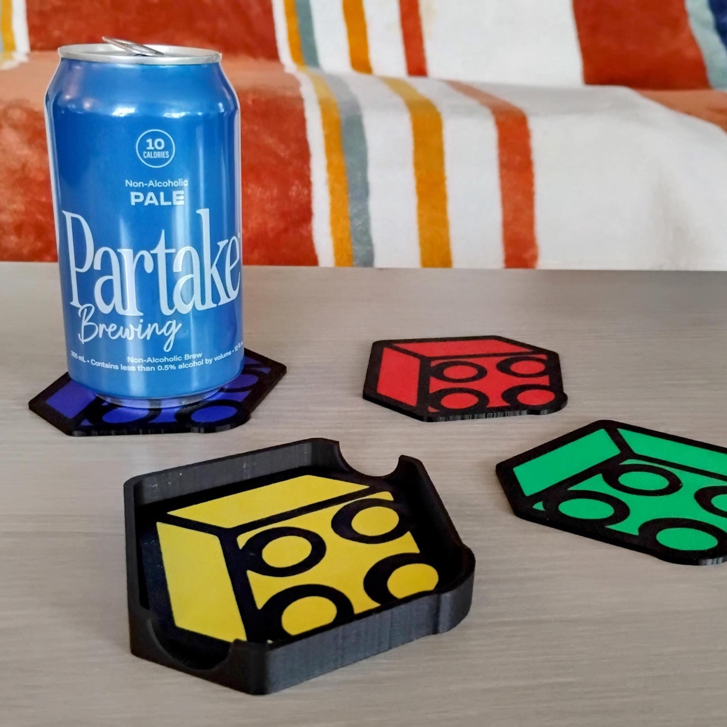 Brick-inspired coasters shown on a table with a drink can