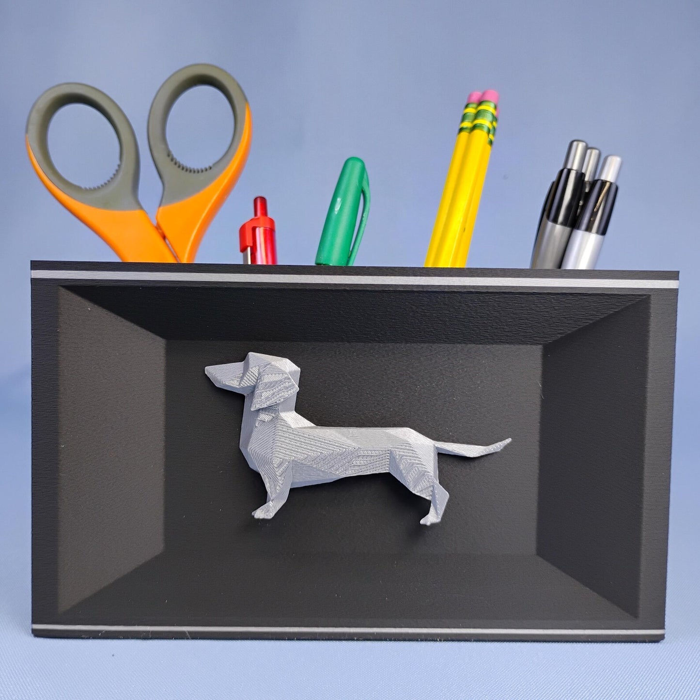 Gray geometric Dachshund desk caddy with removable dividers holding pens, pencils, and scissors