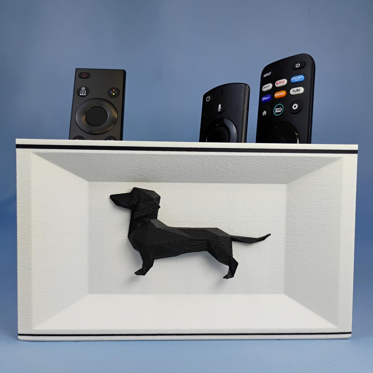 White Dachshund desk organizer holding TV remotes with raised black Dachshund detail on the front