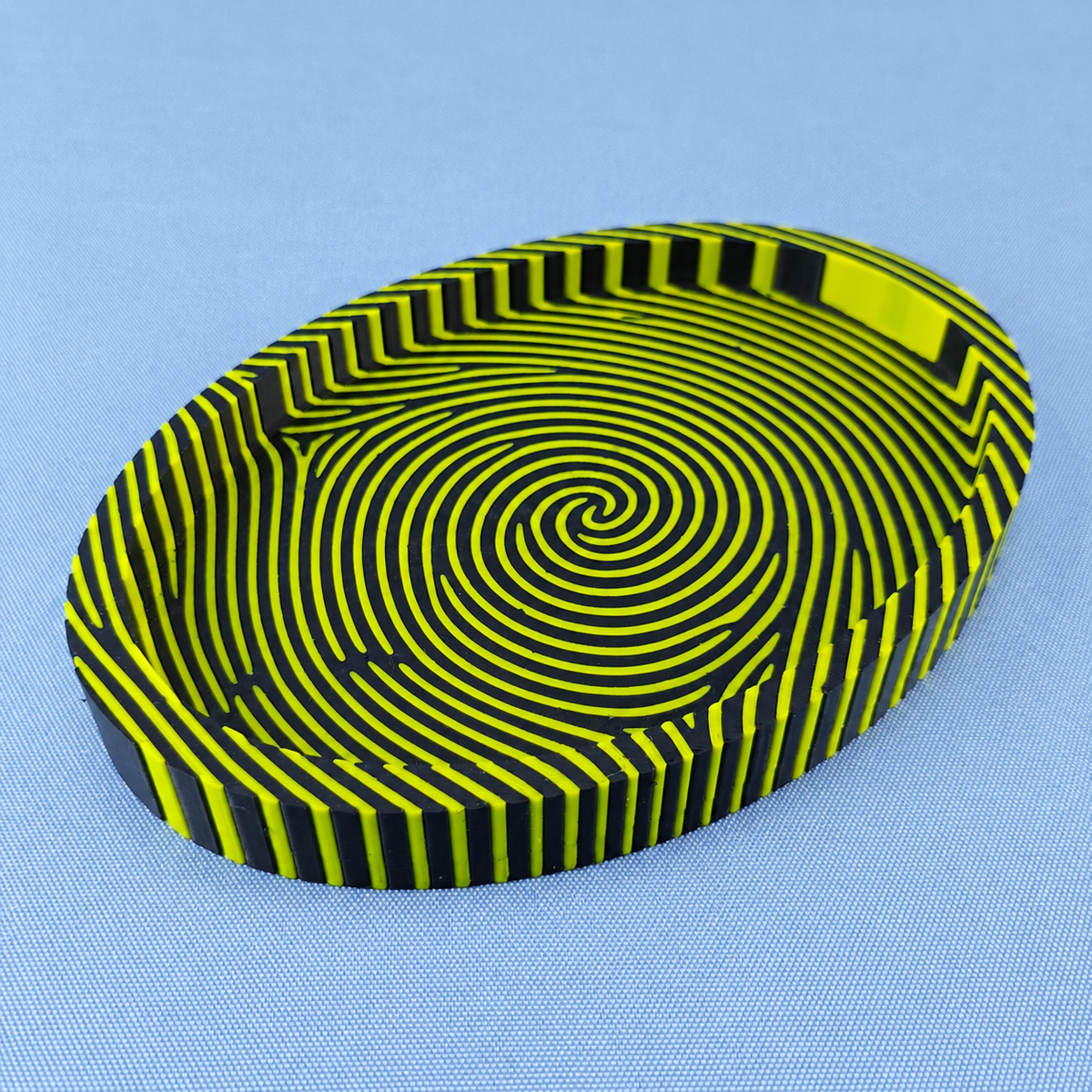 Black and yellow fingerprint catchall tray showing the bold striped fingerprint pattern across the base and sides.