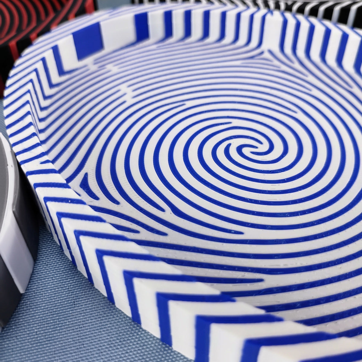 Close-up of a blue and white fingerprint catchall tray showing the fingerprint pattern flowing across the base and up the sides.