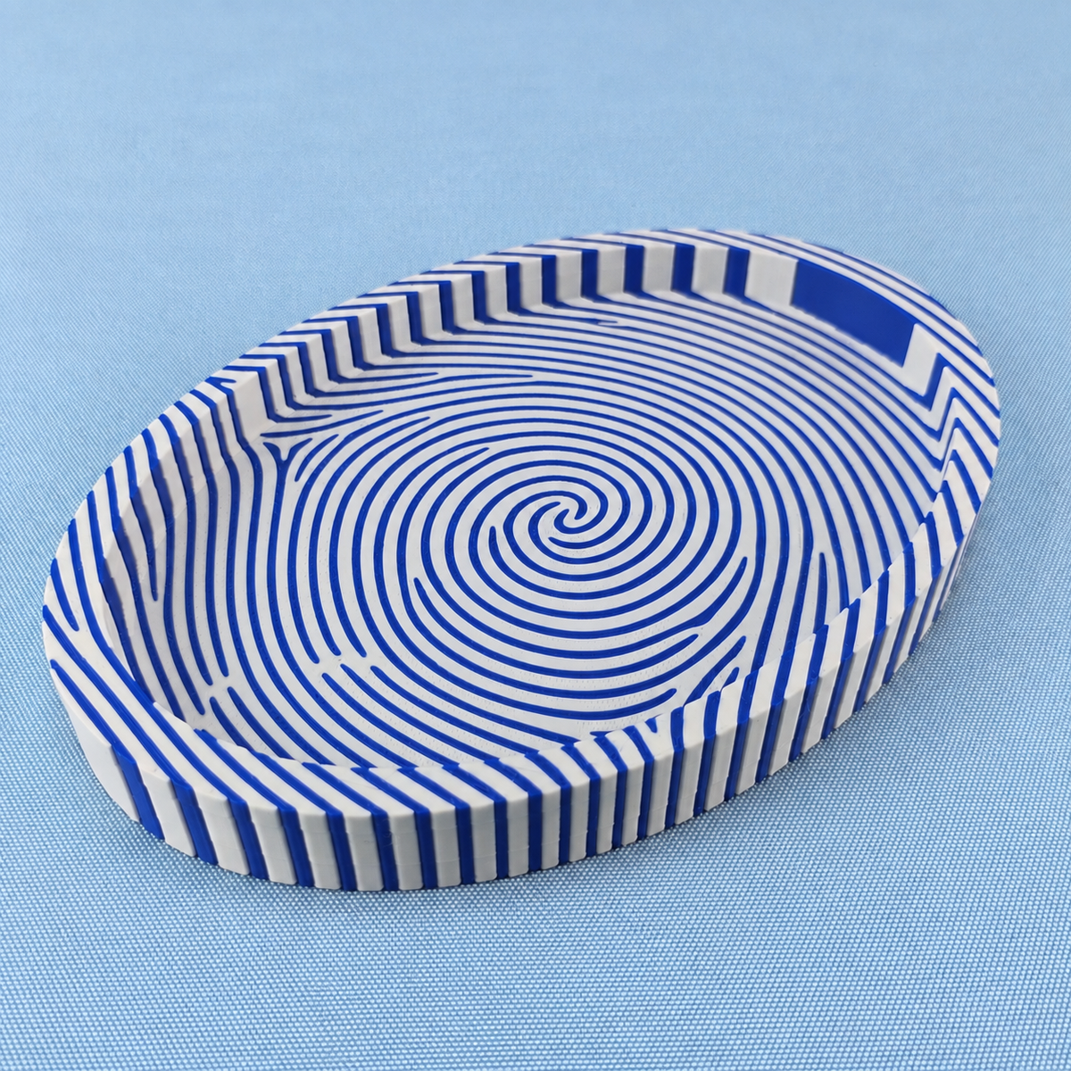 Blue and white fingerprint catchall tray showing the bold striped fingerprint pattern across the base and sides.