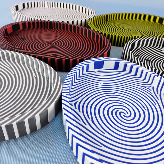 Fingerprint catchall trays in blue and white, red and black, yellow and black, gray and white, and black and white color combinations.