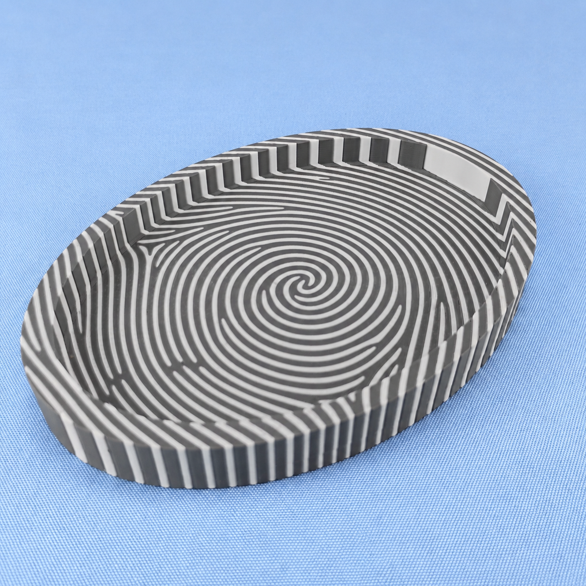 Grey and white fingerprint catchall tray showing the bold striped fingerprint pattern across the base and sides.