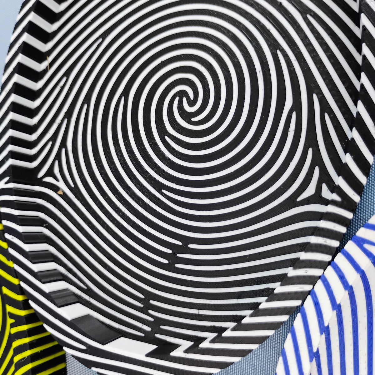 Close-up of a black and white fingerprint catchall tray showing the striped fingerprint pattern continuing across the base and up the sides.