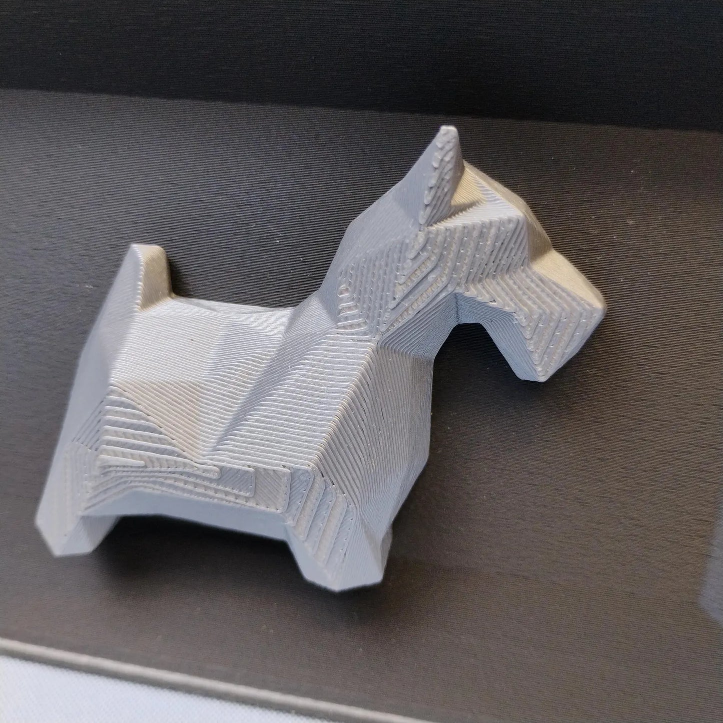 Close-up of raised geometric Scottish Terrier detail used on the front of the desk organizer