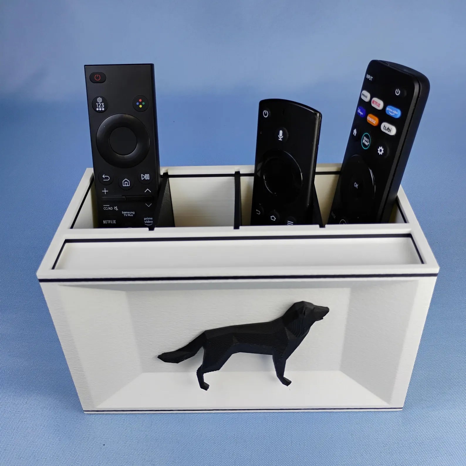 White German Shepherd remote holder with black dog detail photographed on a blue background