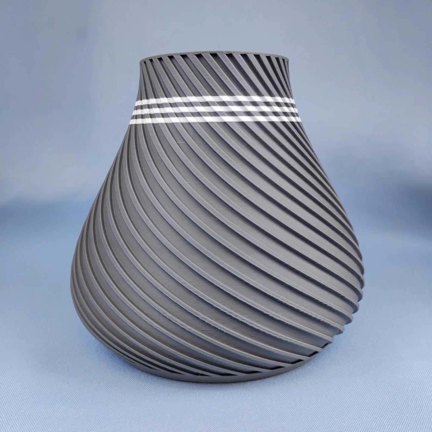 Gray swirly vase with rounded modern shape and spiral surface texture