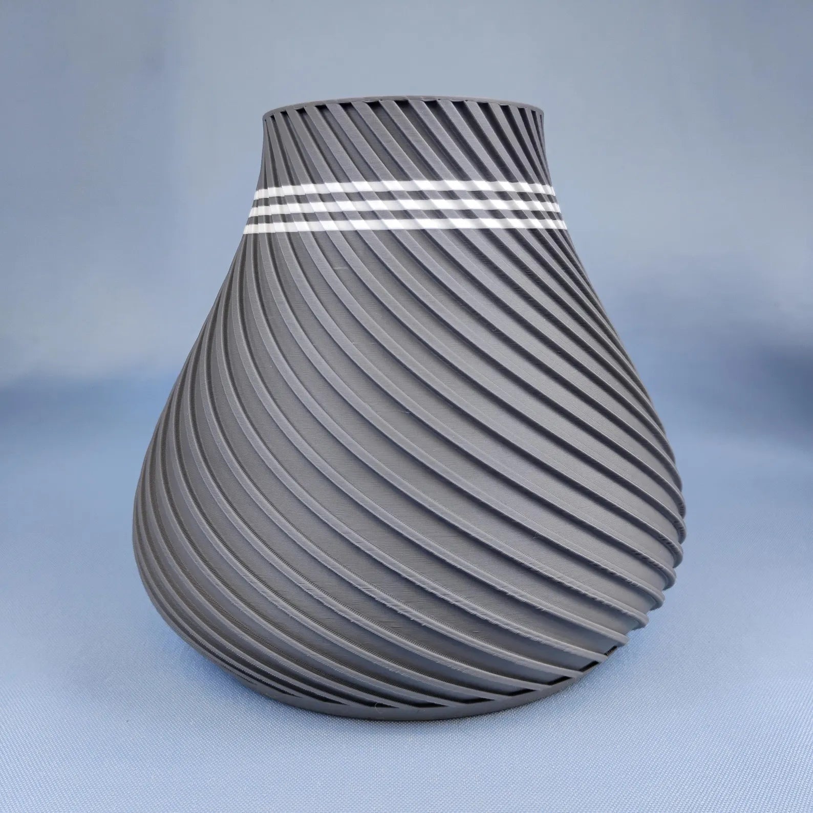 Gray swirly vase with rounded modern shape and spiral surface texture