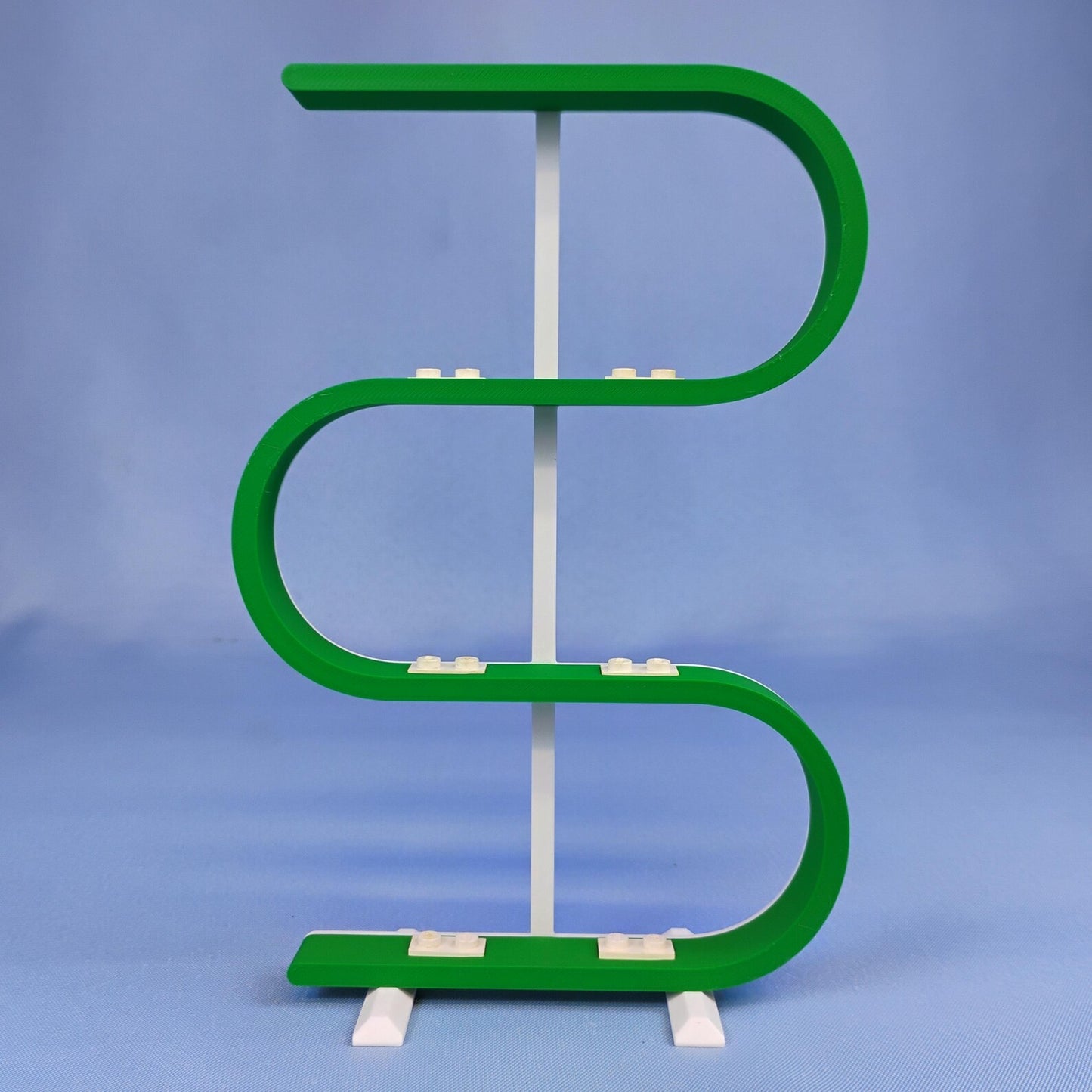 Empty green squiggle display stand for LEGO® minifigures on a blue background