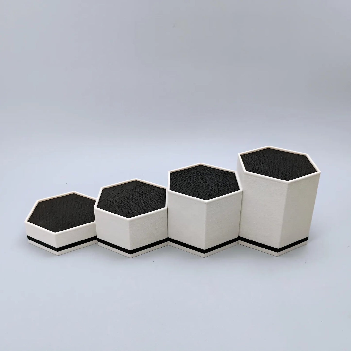 Side view of empty hex display stands showing the stepped height difference between 1 inch, 2 inch, 3 inch, and 4 inch stands.