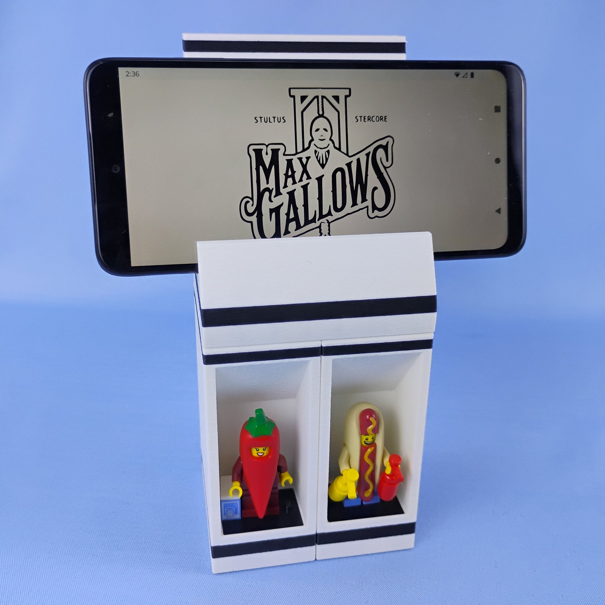 Smartphone positioned horizontally on the modular phone stand above two LEGO® minifigure display compartments.