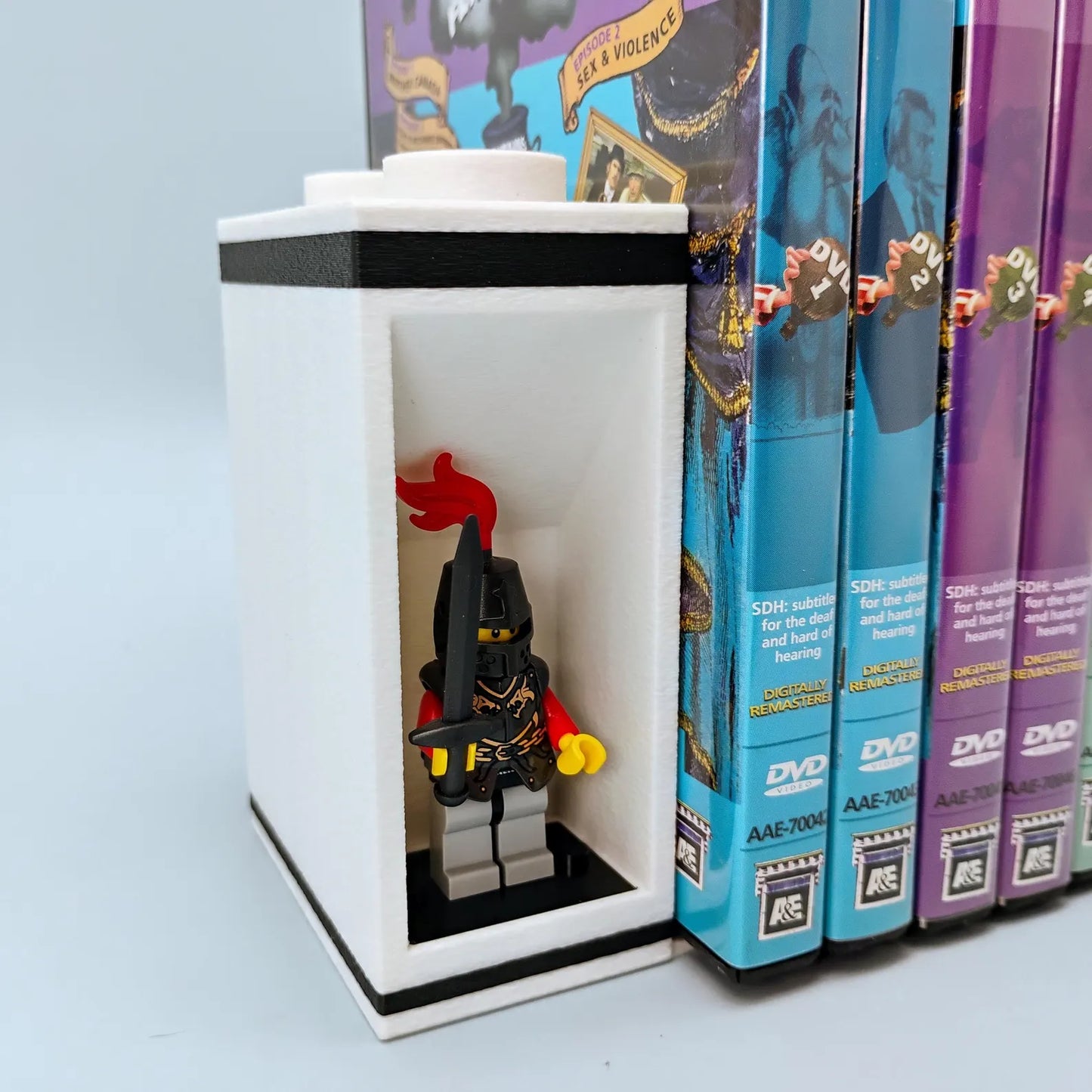 White bookend beside DVD cases with a LEGO® minifigure displayed in the recessed alcove