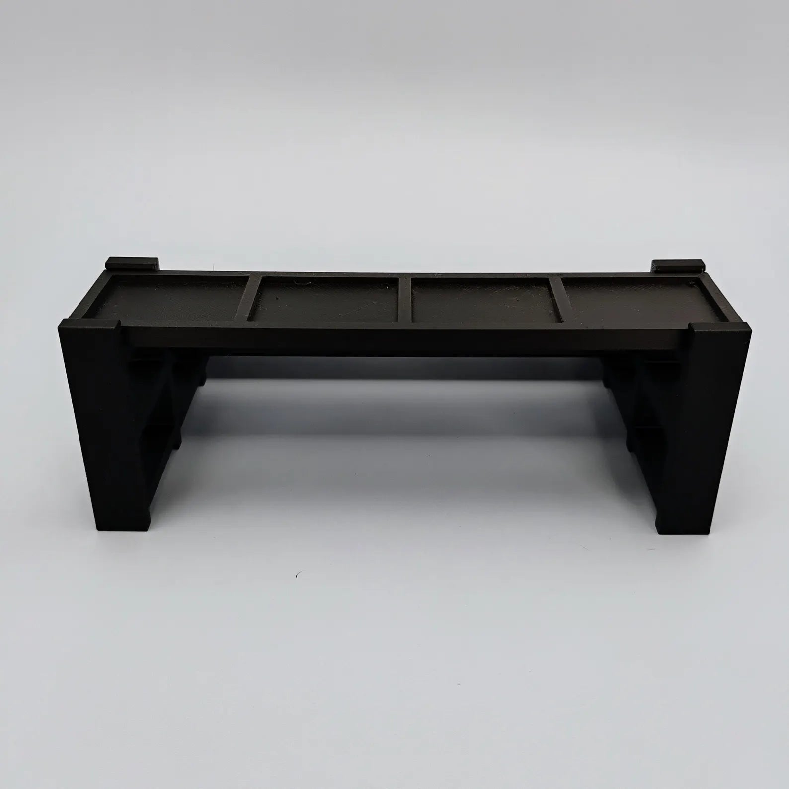 Smaller black display stand for LEGO® minifigures shown empty on a white background.