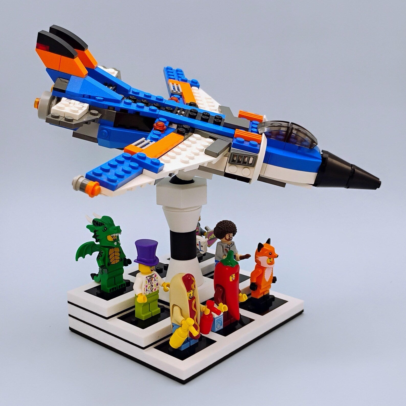LEGO® airplane posed on a white adjustable display stand with minifigures arranged on the base for a clean shelf display.