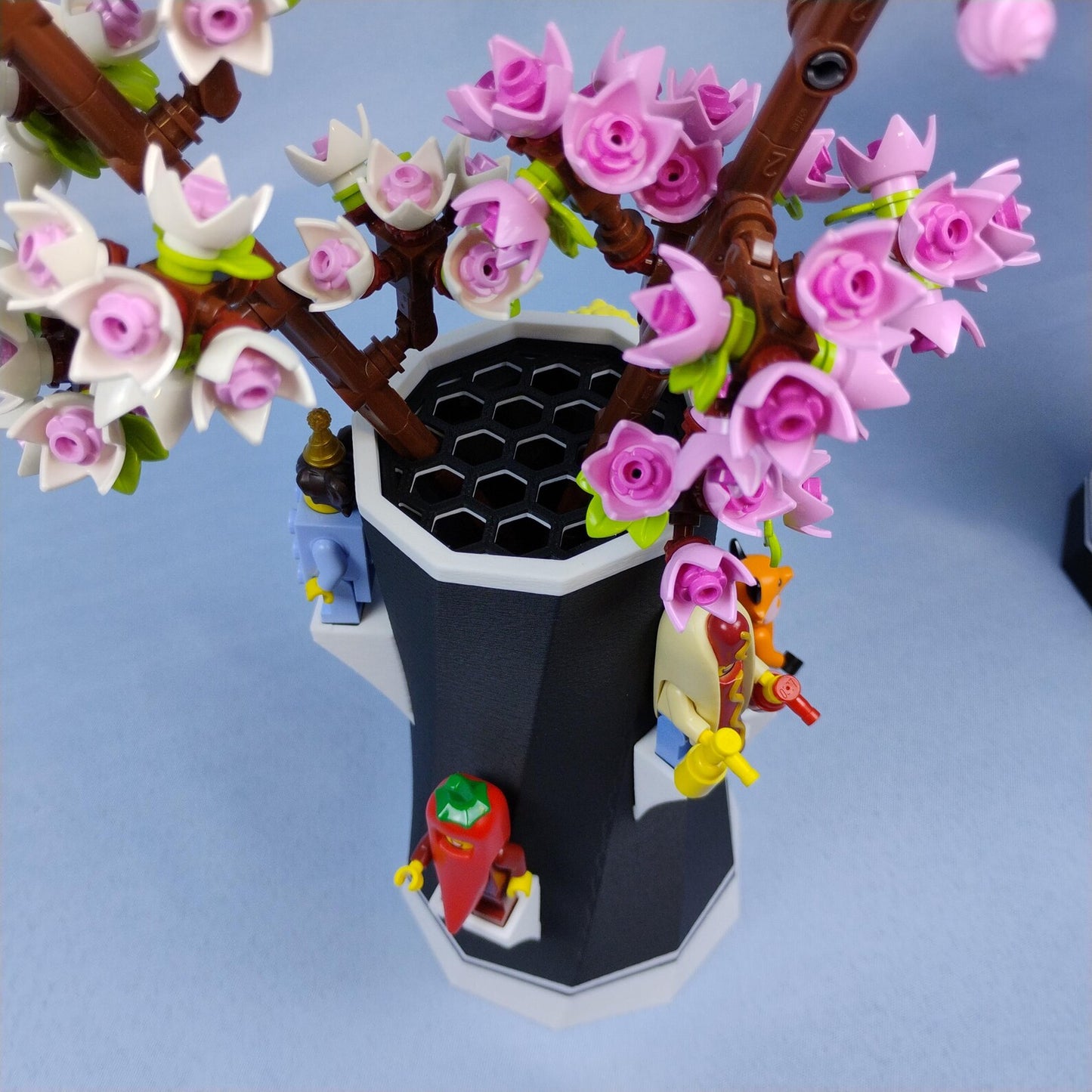 Top view of LEGO® botanical vase with flower stems and minifigures displayed around the base