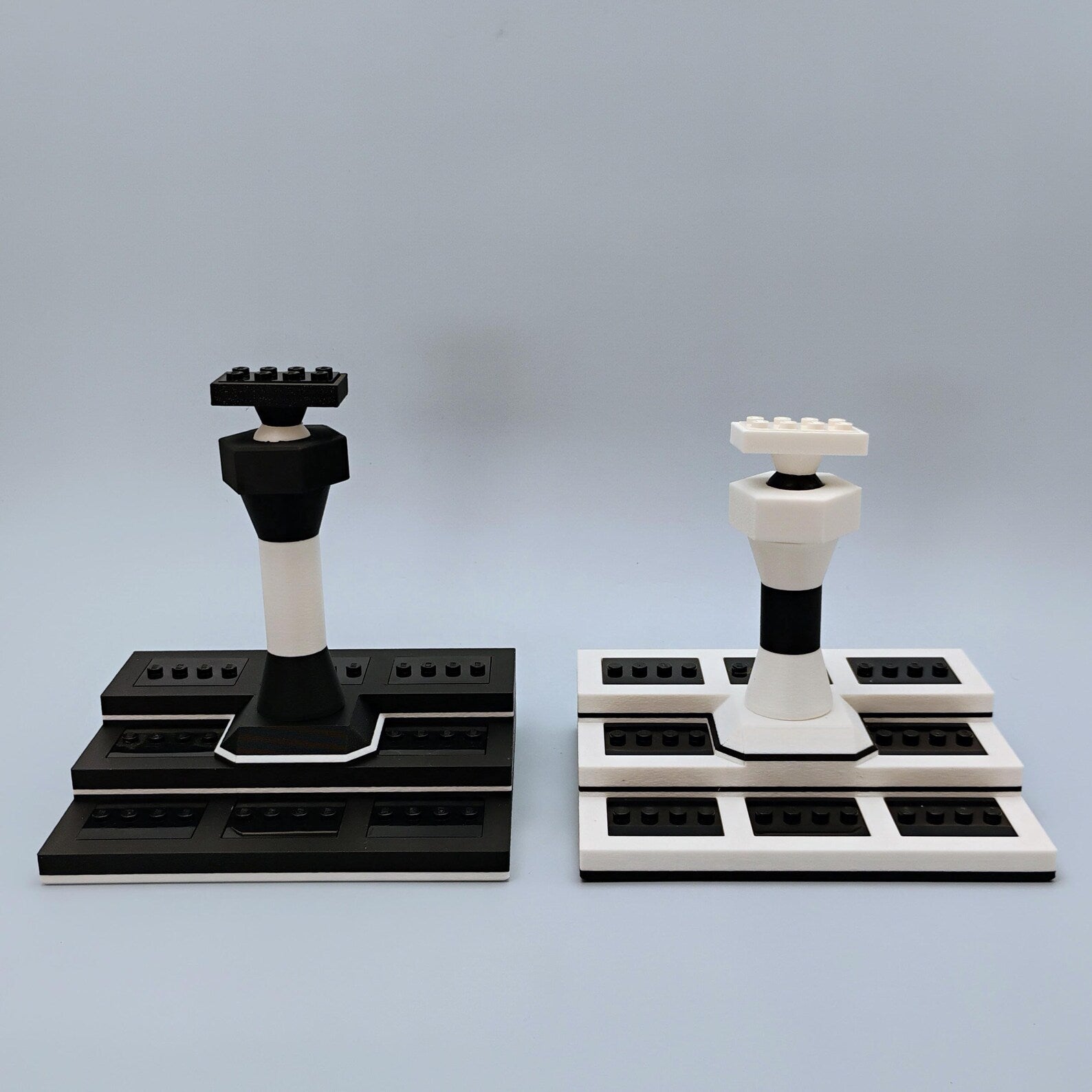 Black and white LEGO® display stand color options with rectangular bases, support columns, and adjustable top mounts.