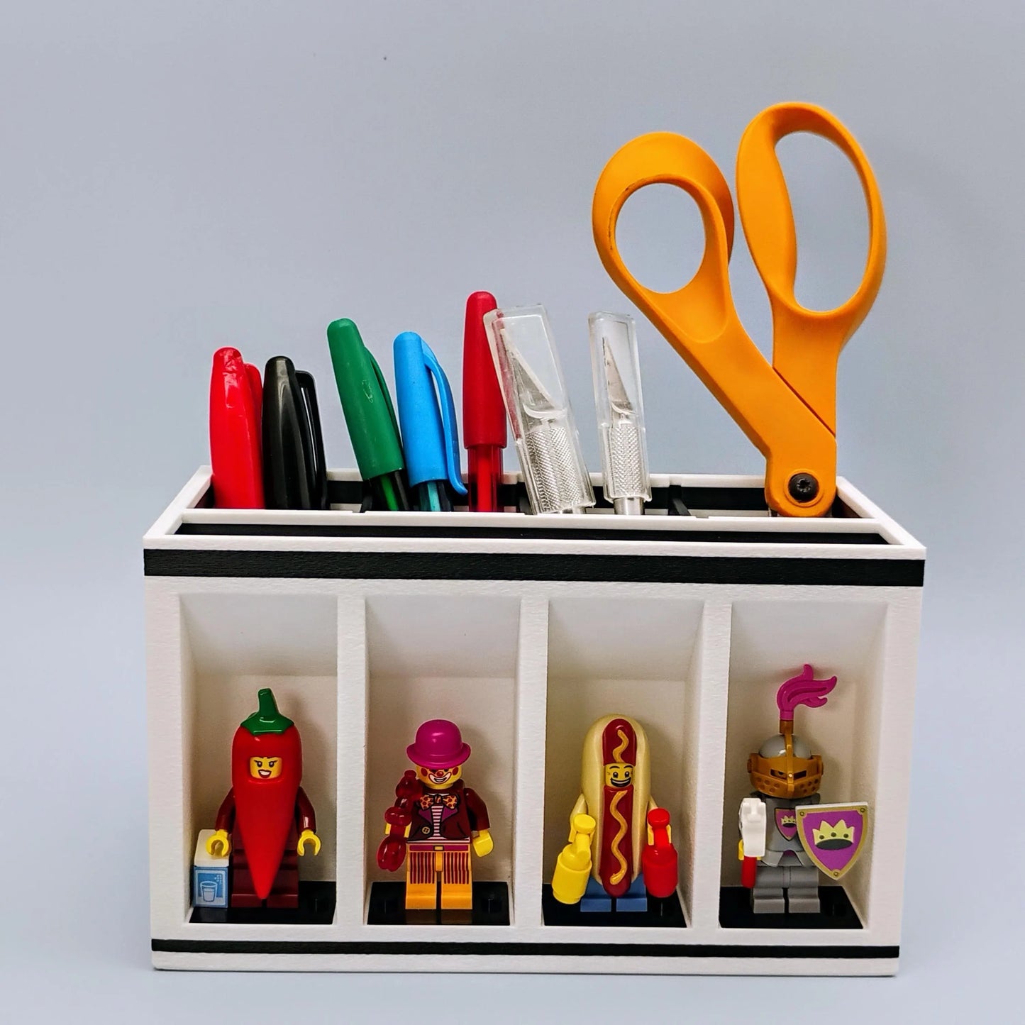 Desk organizer with colorful markers, scissors, and LEGO Minifigures being displayed.