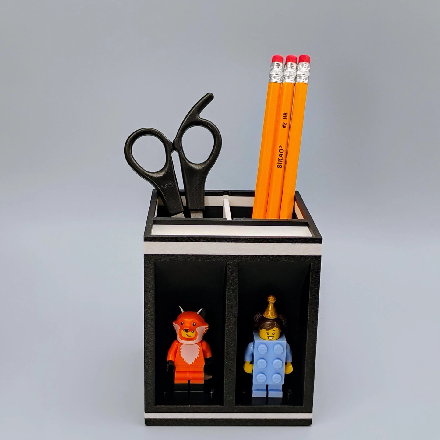 Pencil holder with LEGO figures and pencils on a gray background