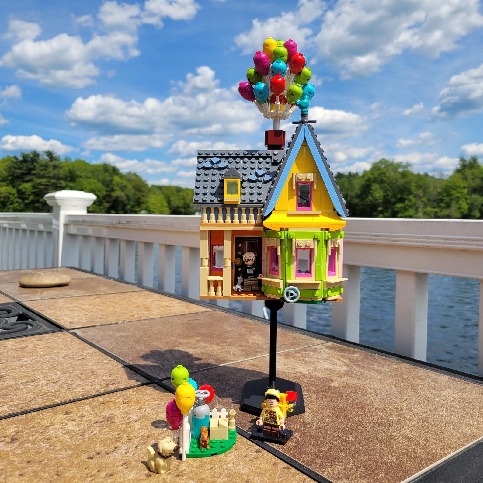 LEGO® house build displayed outdoors on a black 4.5 inch riser stand, showing use for small builds and dioramas.
