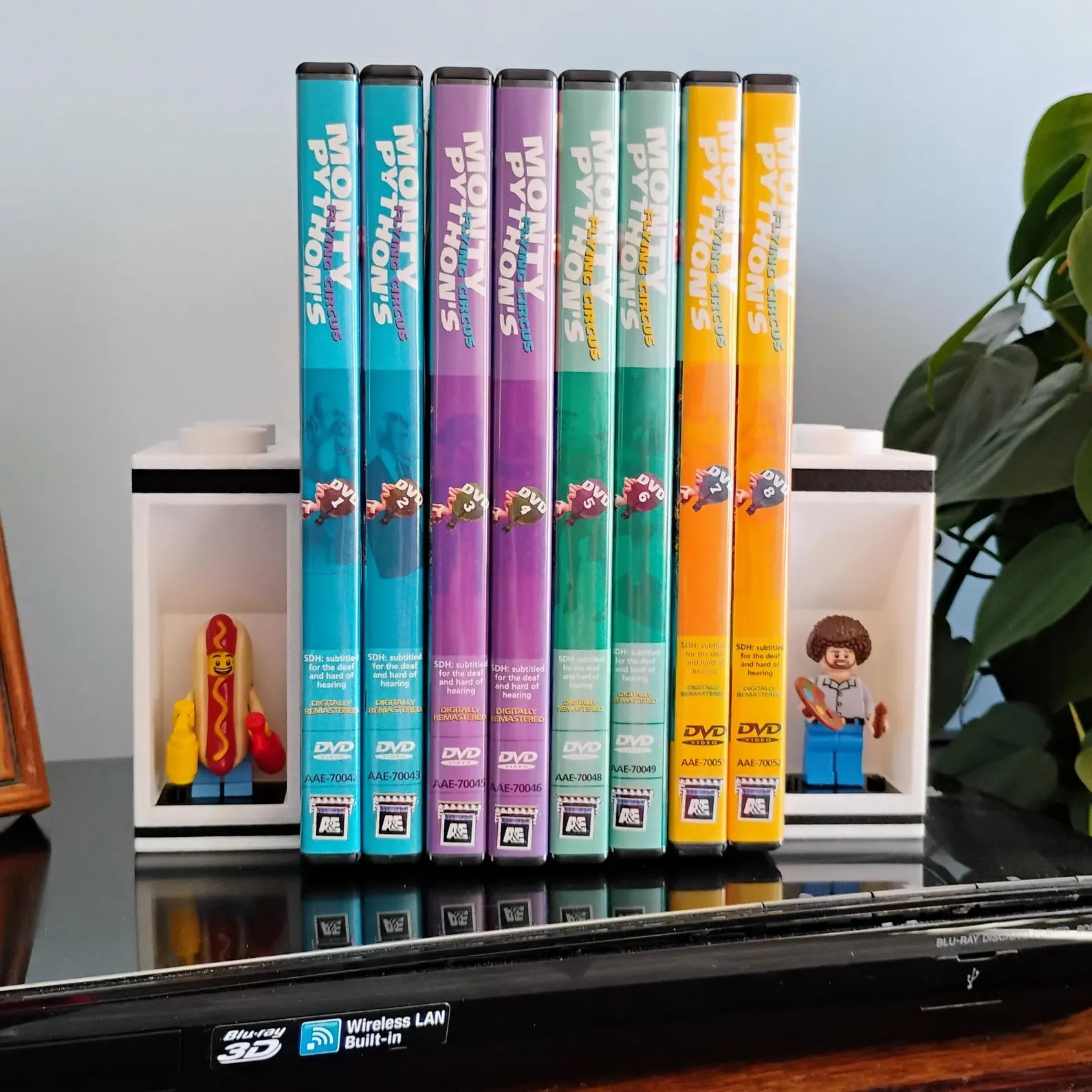 White bookends holding colorful DVD cases with LEGO® minifigures displayed in side alcoves