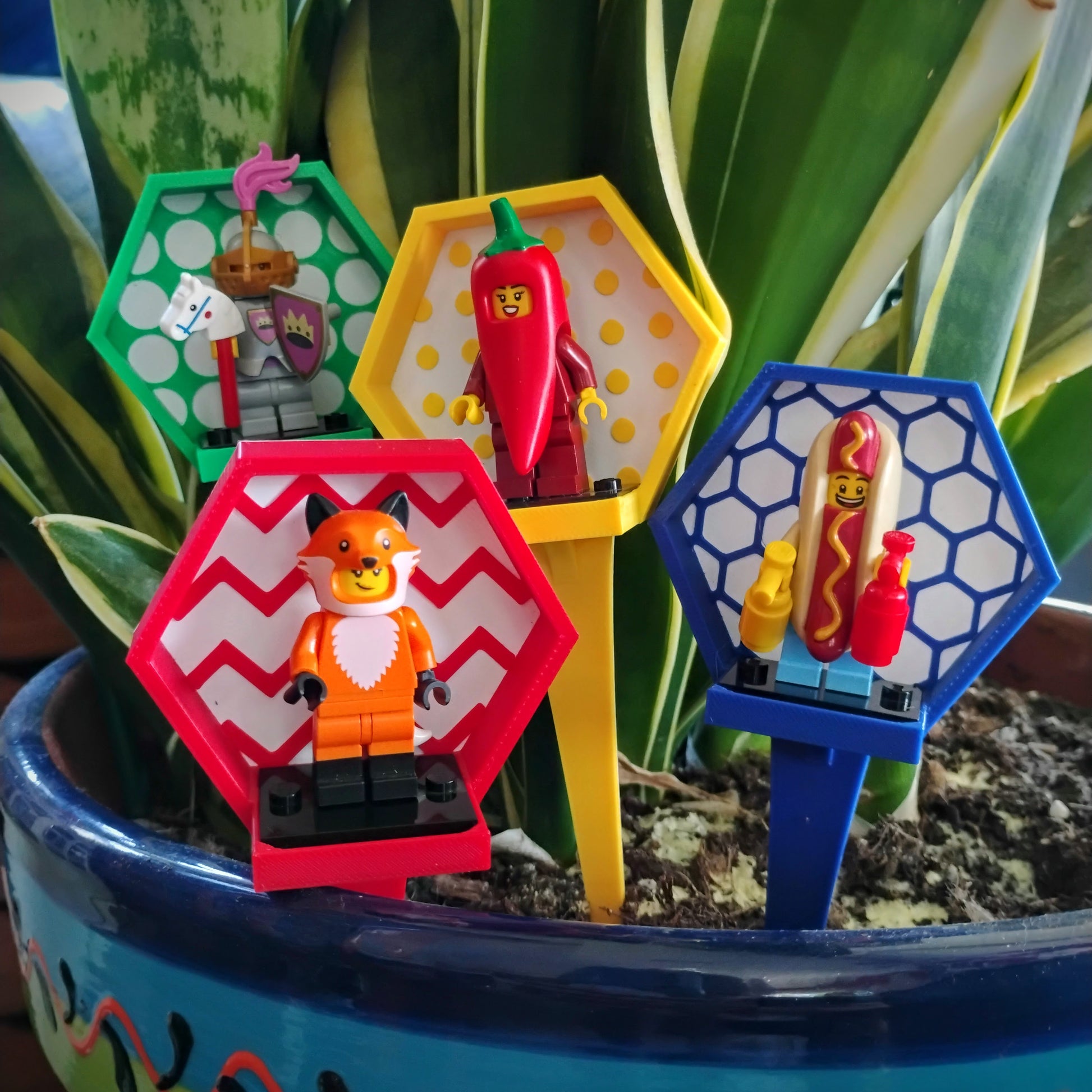 Colorful LEGO® minifigure plant stakes used together in a planter to create a miniature garden display scene.