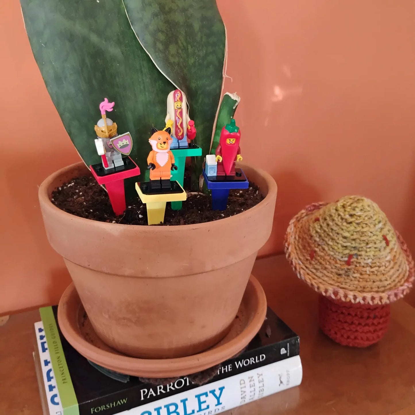 LEGO® minifigures displayed on colorful plant stakes in a terracotta pot
