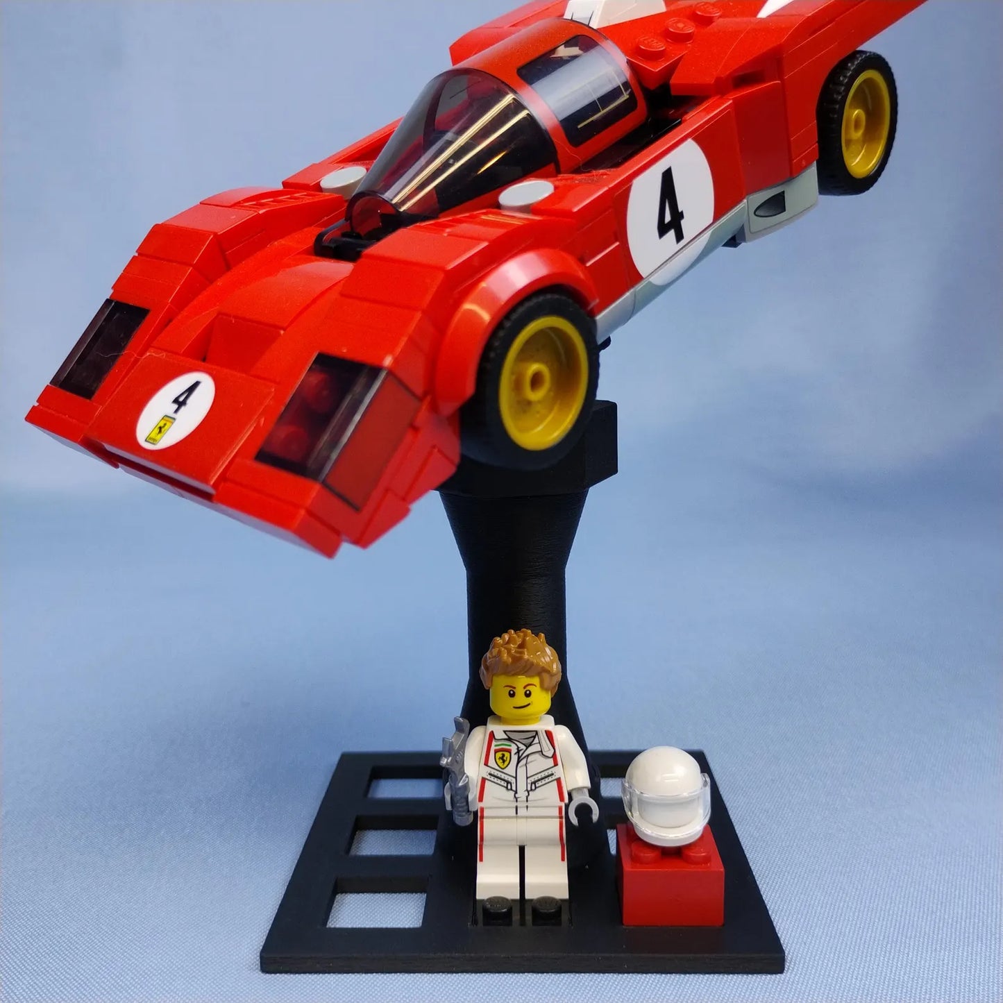 Adjustable black display stand holding a red LEGO® Speed Champions style race car with minifigure display area on the base.
