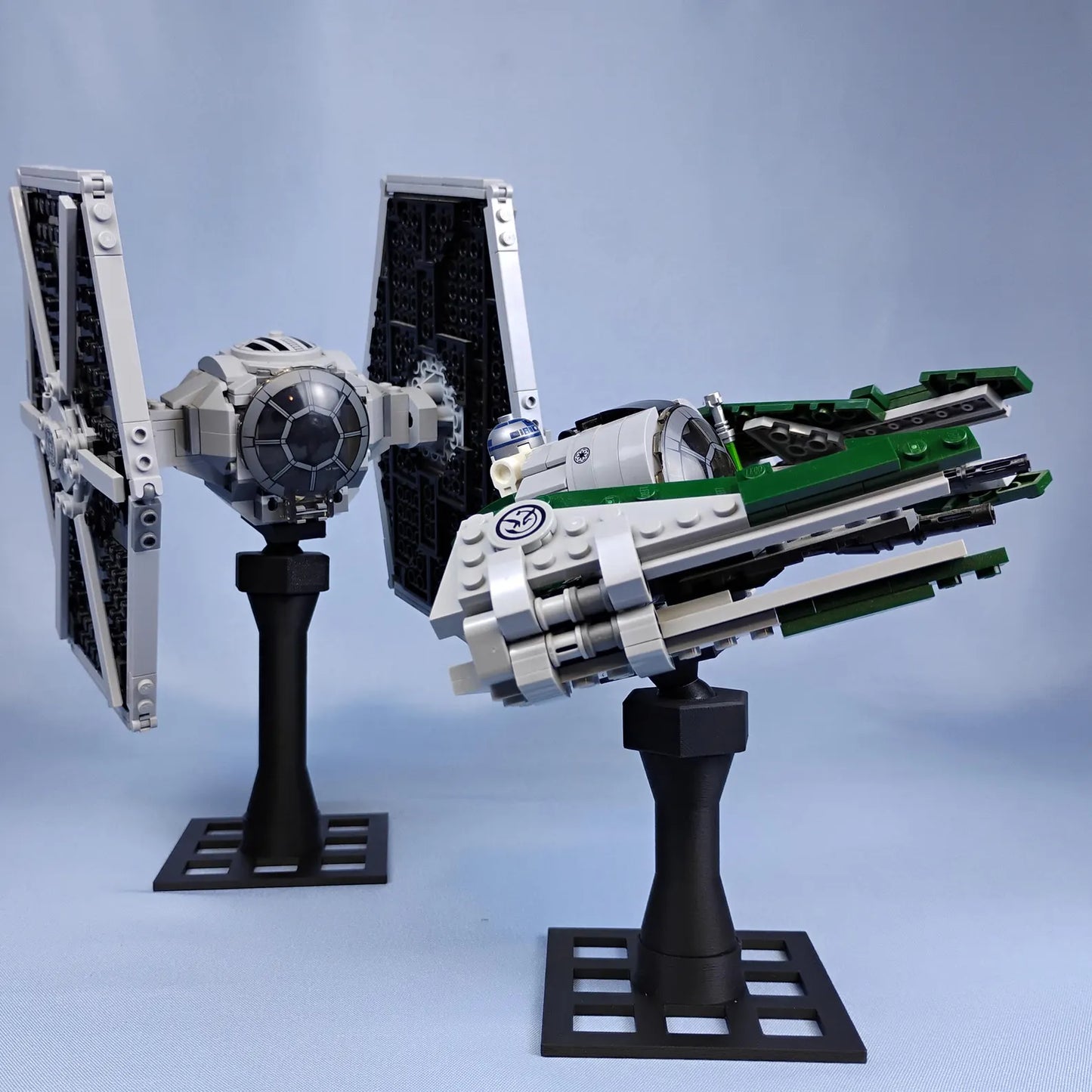Pair of black adjustable display stands holding LEGO® Star Wars style ships with angled support columns and display bases.