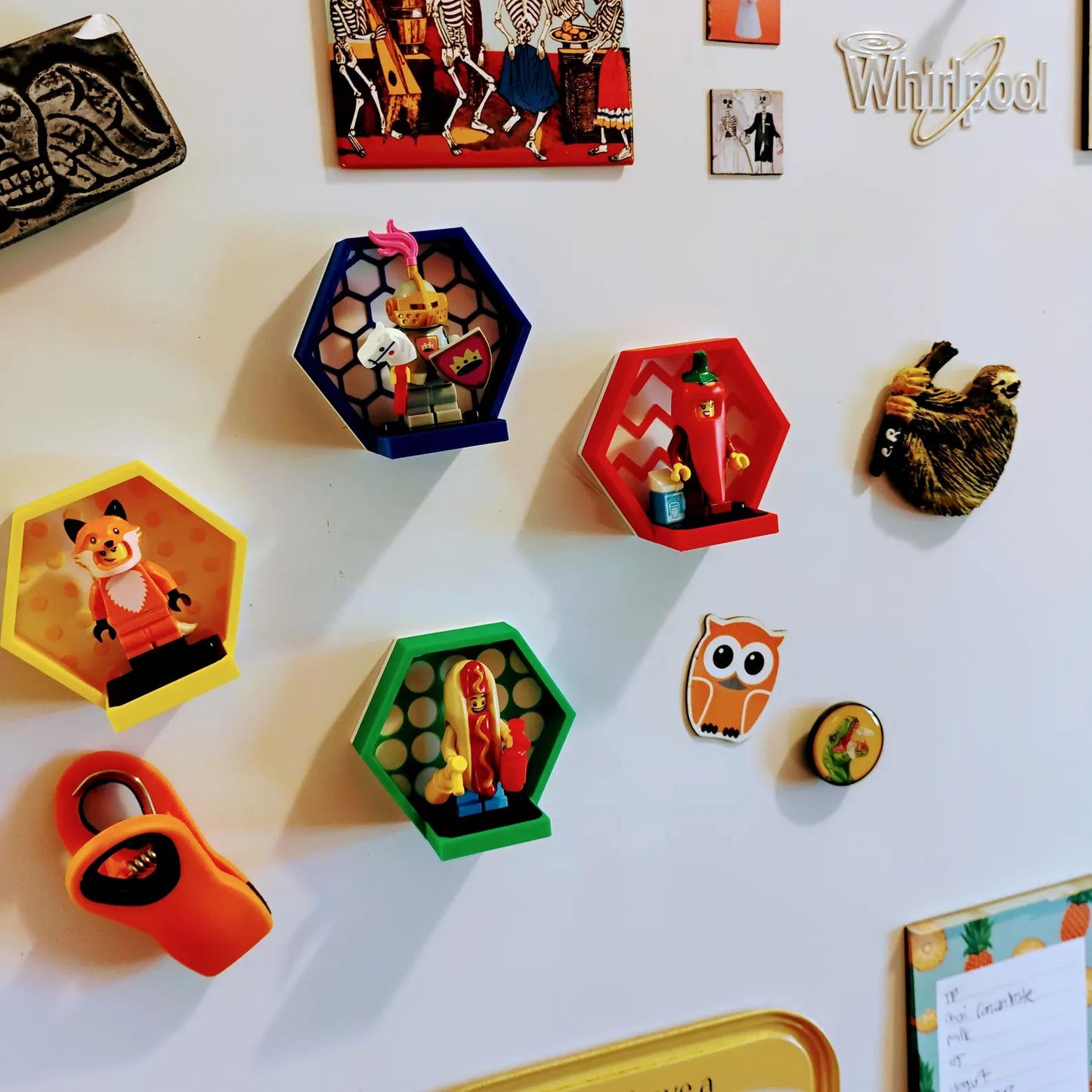 Magnetic hexagon minifigure displays attached to a refrigerator with LEGO® figures and colorful display frames.